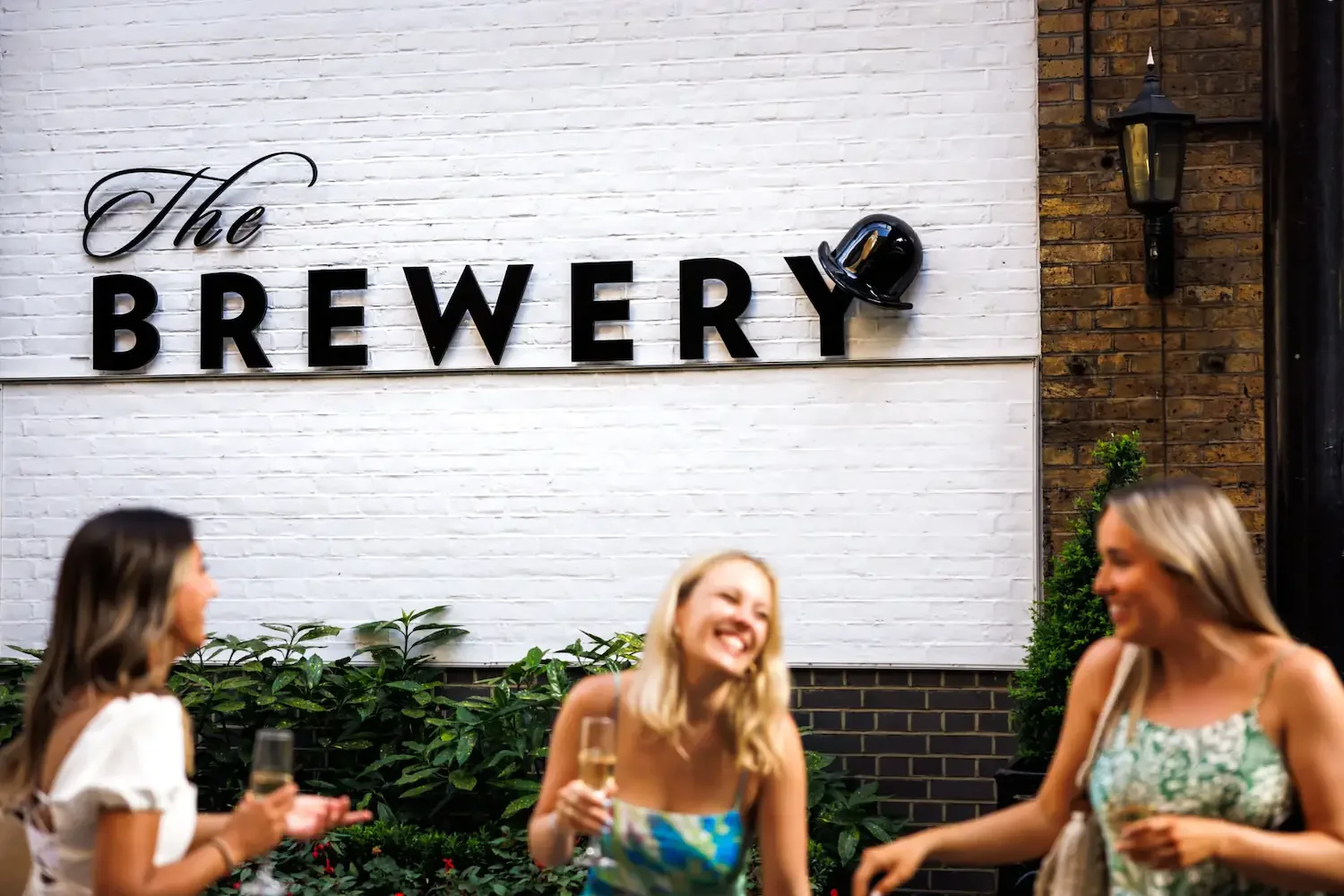 Guests smiling during a drinks reception at The Brewery