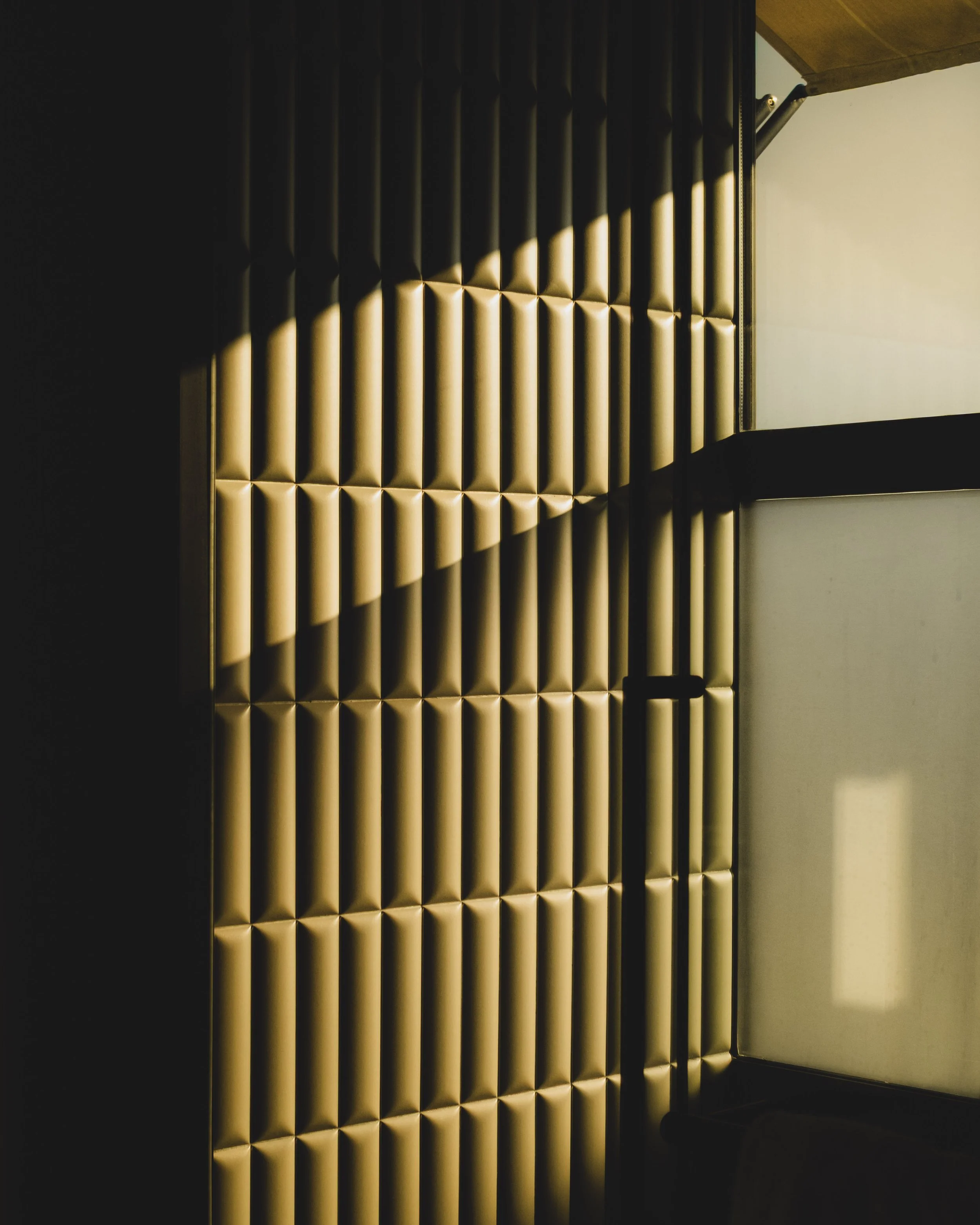 Luxurious hotel bathroom with padded wall panels illuminated by soft lighting, creating a warm ambiance.