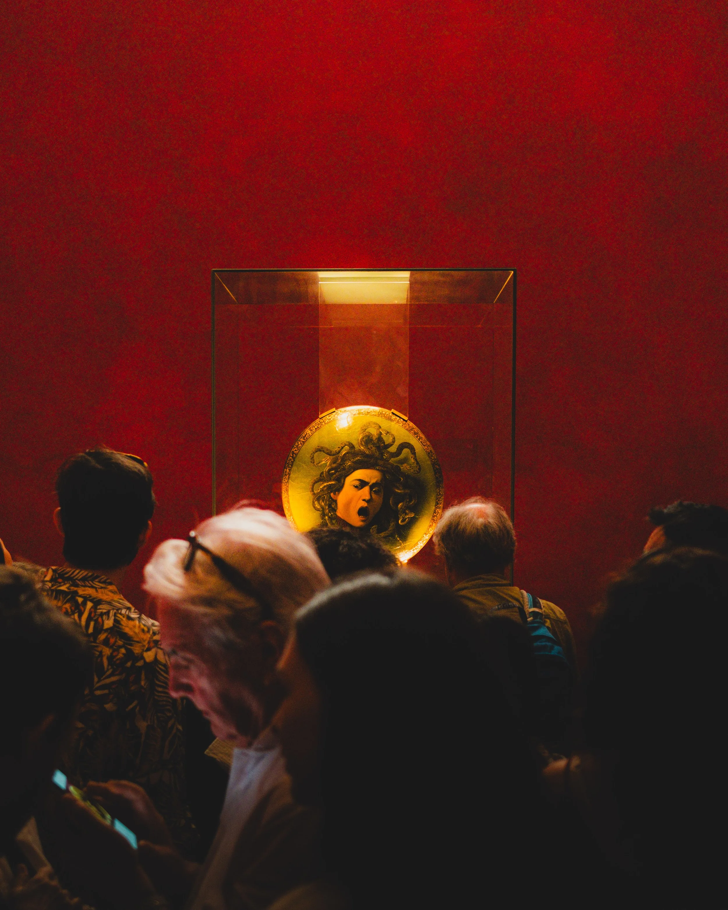 People viewing a Medusa medallion artwork in a museum. Lionel Chu - Hotel & Travel Photographer