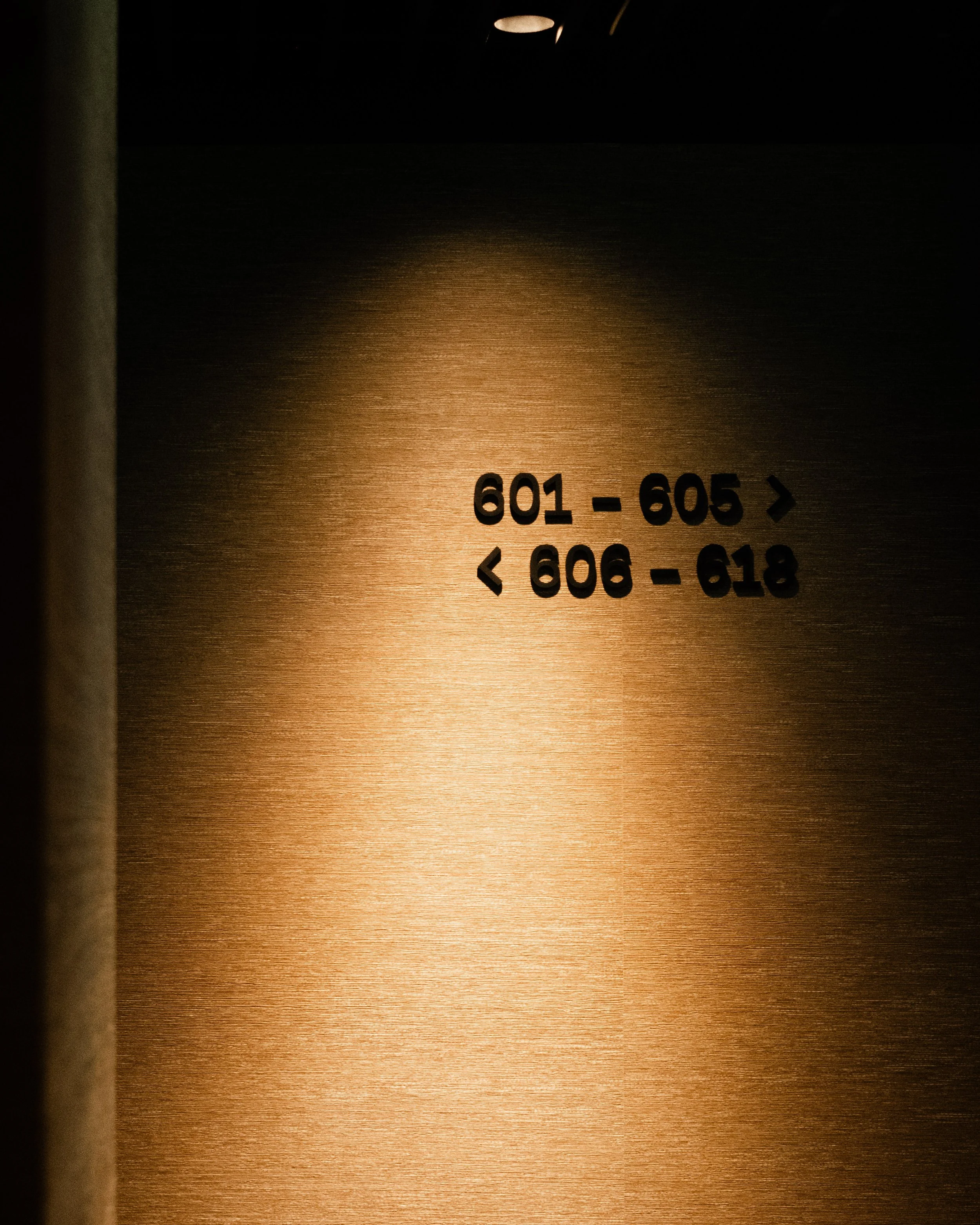 Elevator directory with floor ranges 601-605 and 606-618, with arrows indicating directions. Lionel Chu - Hotel & Travel Photographer