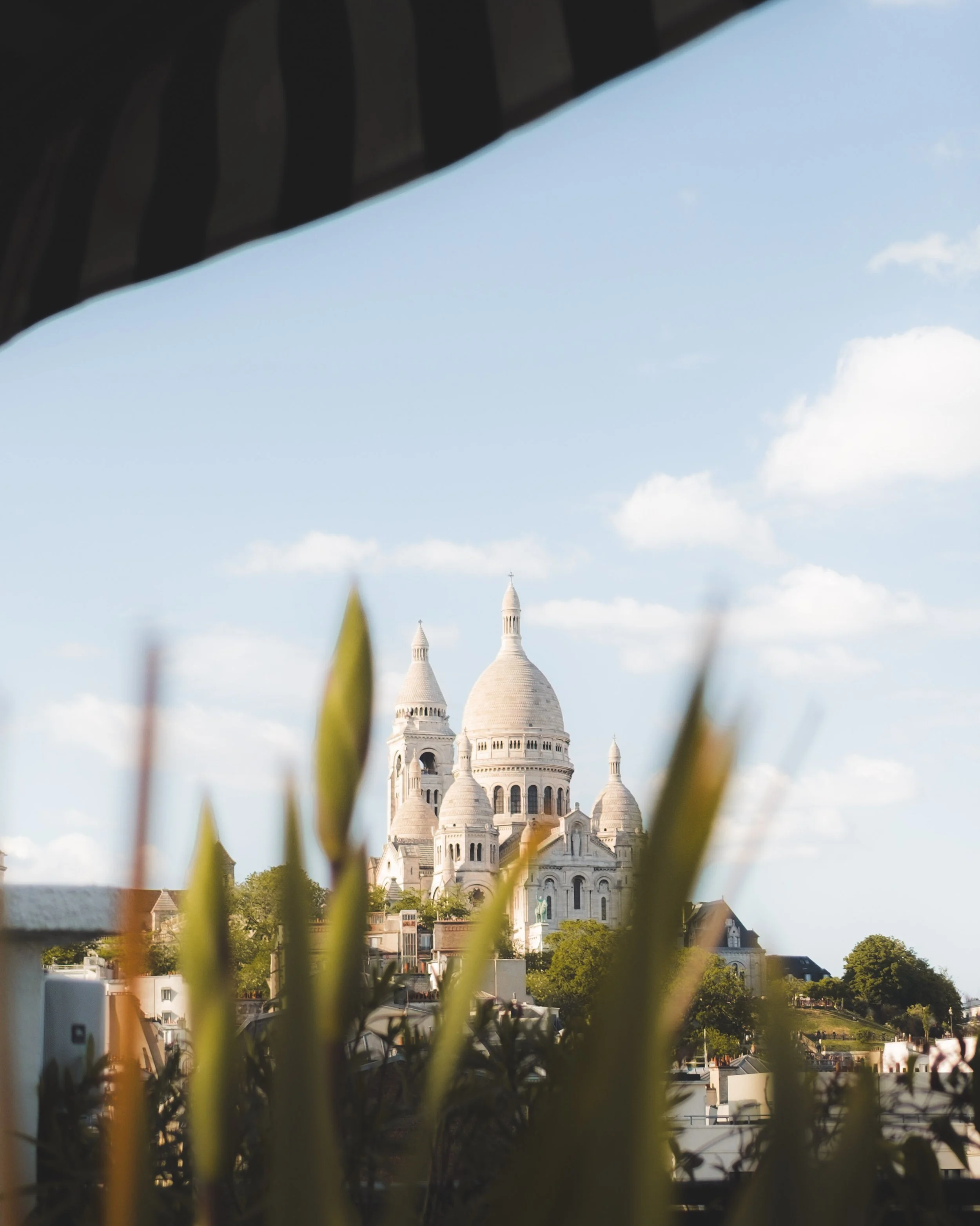 View of the Sacré-Cœur Basilica in Paris from the rooftop of a luxury hotel on a clear day