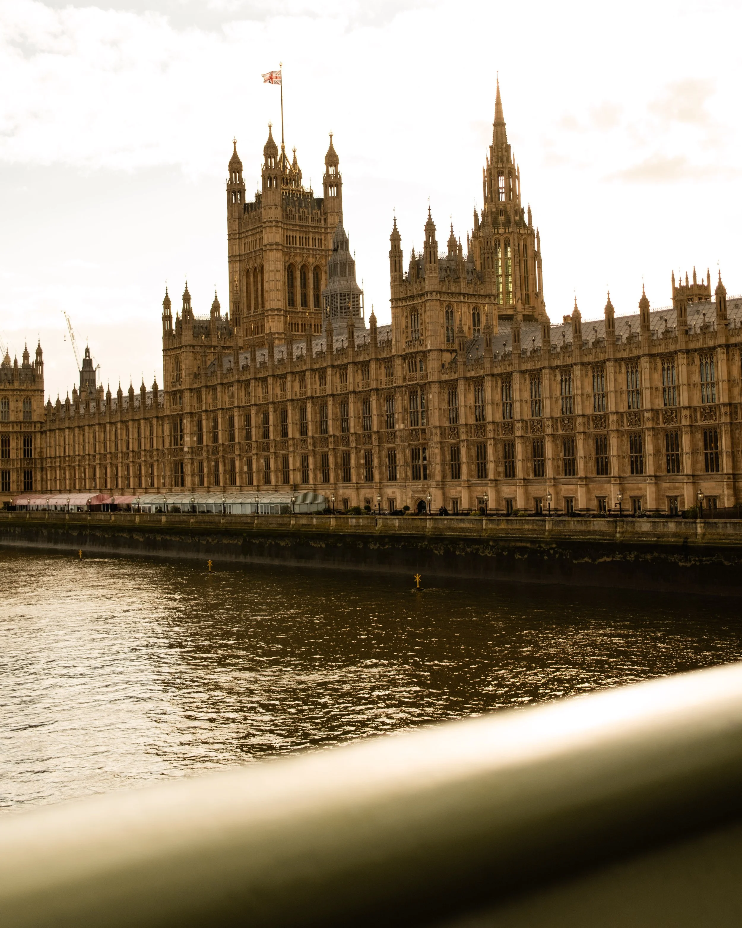 The Palace of Westminster in London, England, showing the historic Gothic architecture along the river Thames with some cloudy skies in the background. Lionel Chu - Hotel & Travel Photographer