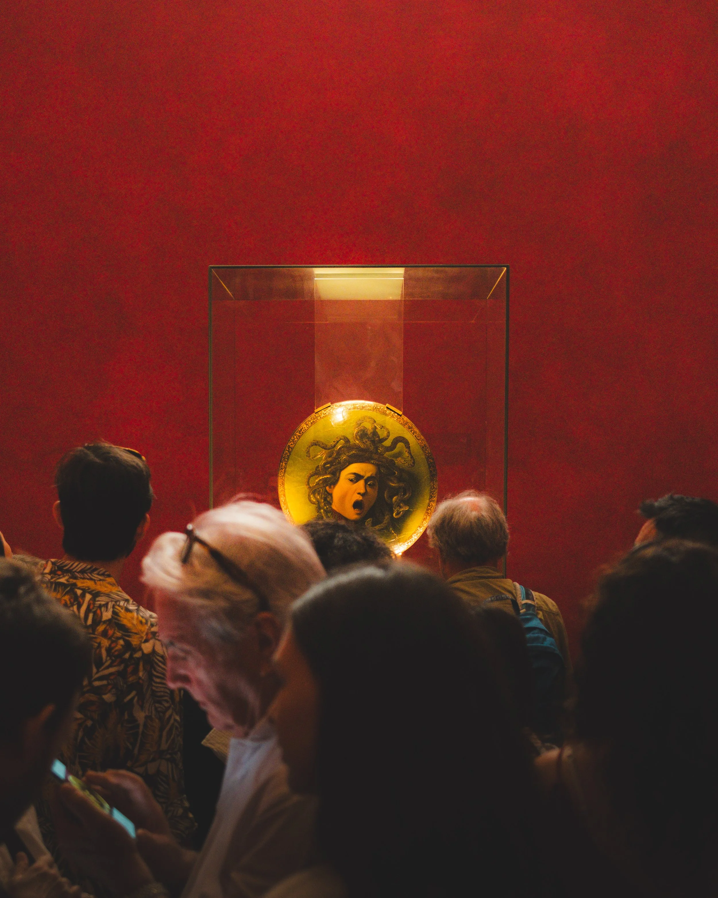 People viewing a Medusa medallion artwork in a museum. Lionel Chu - Hotel & Travel Photographer