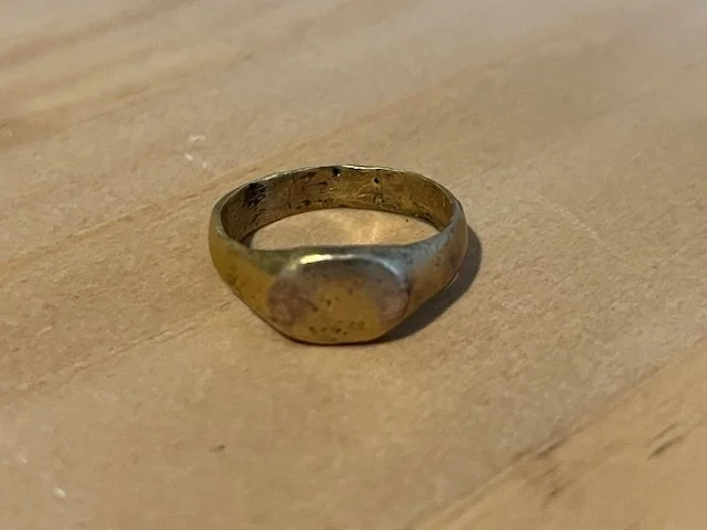 AD 900-1050. Iconic form C. 900-1050 AD. Rounded face band, 4.0mm at the base, flaring to the shoulders and supporting a raised domed oval bezel. Surface textured from burial with the 24 karat gold restored. 