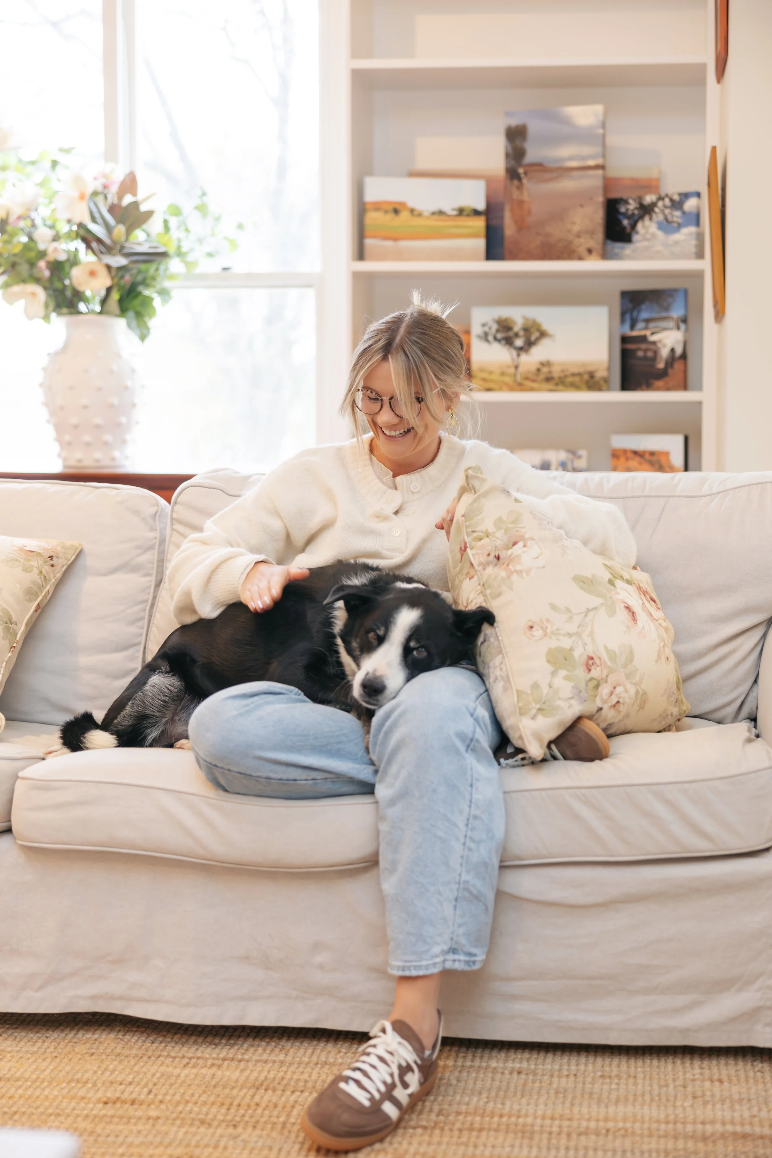 Millie Hardie sitting on her couch with Bear, her retired therapy dog, reflecting the warm and homely feel of The Pocket Psychologist