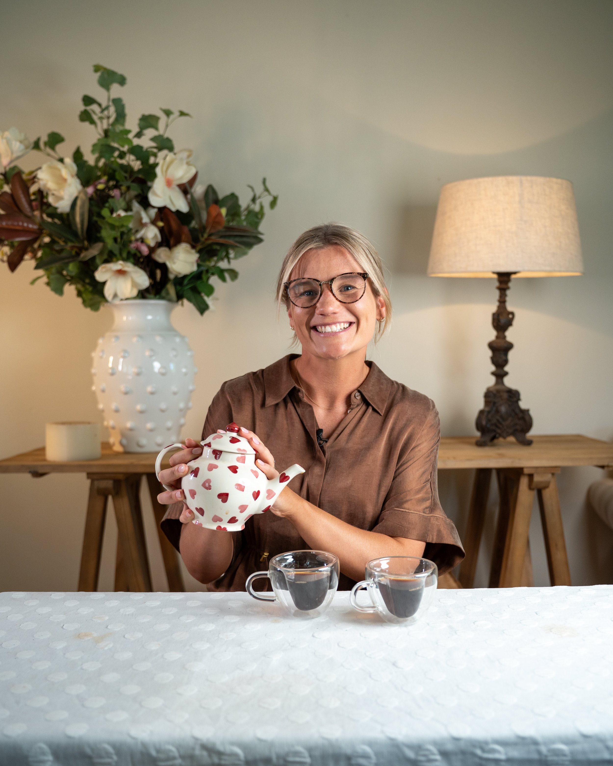 Millie Hardie holding a teapot and smiling, representing the warm and practical approach of the Pep Talk Mini Course by The Pocket Psychologist.