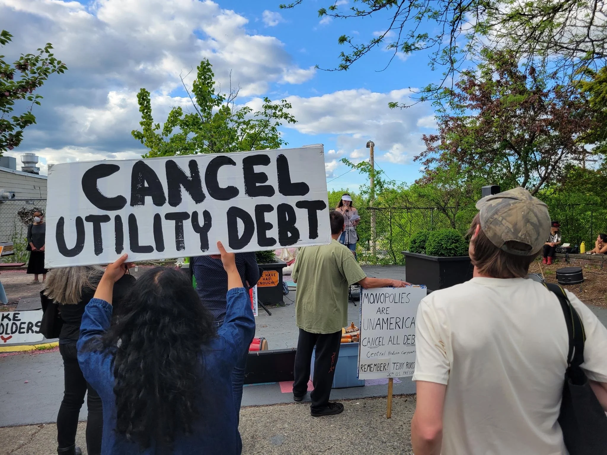 Communities for Local Power at a protest with signs saying "Cancel Utility Debt" and "Monopolies Are Unamerican."