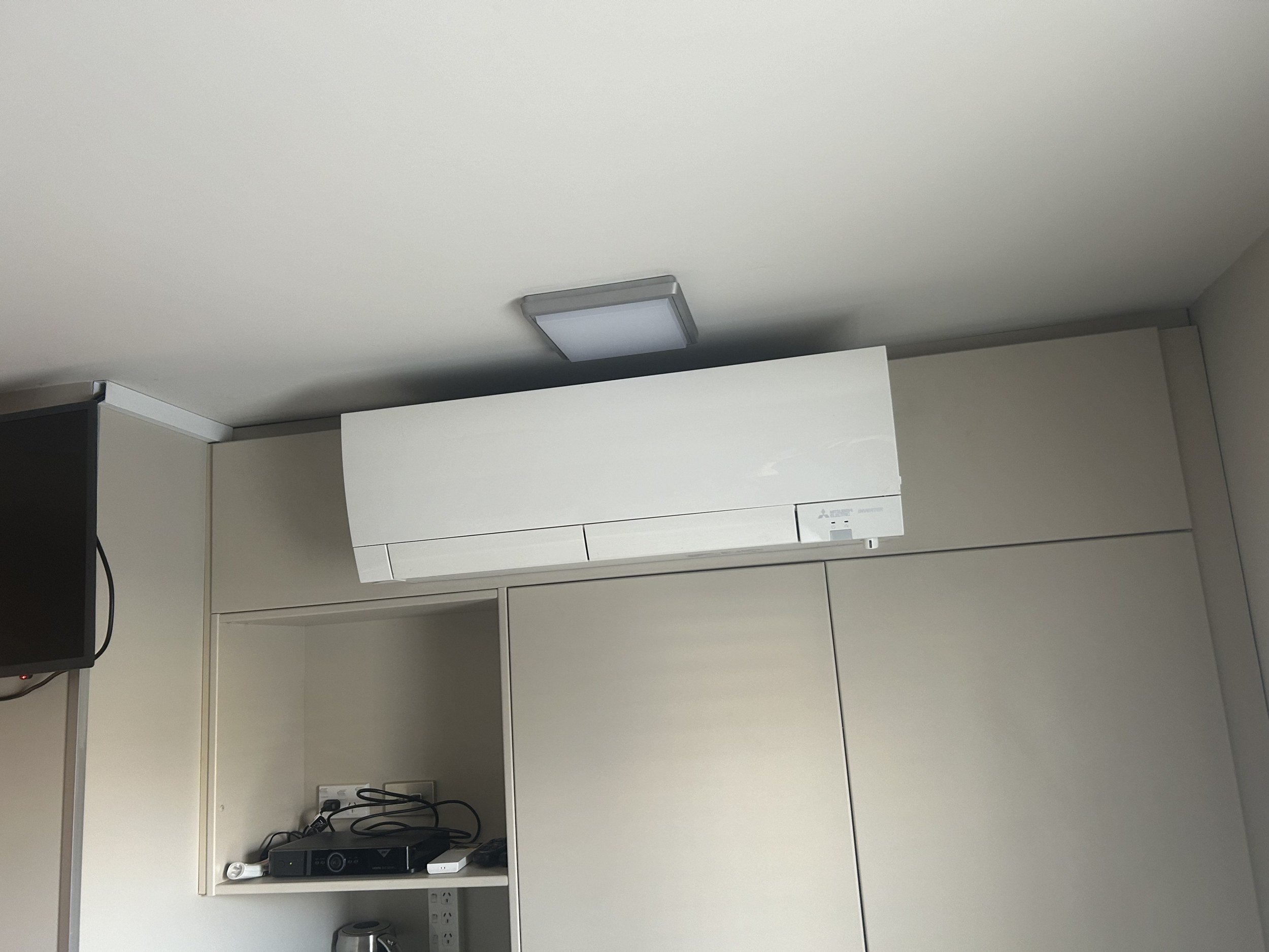 High-wall heat pump installed above kitchen cabinets