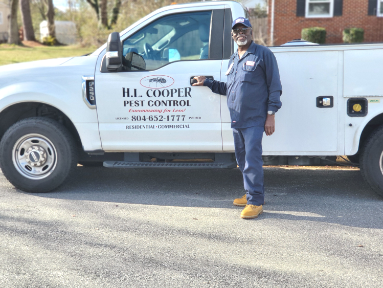 Man in blue uniform beside white truck