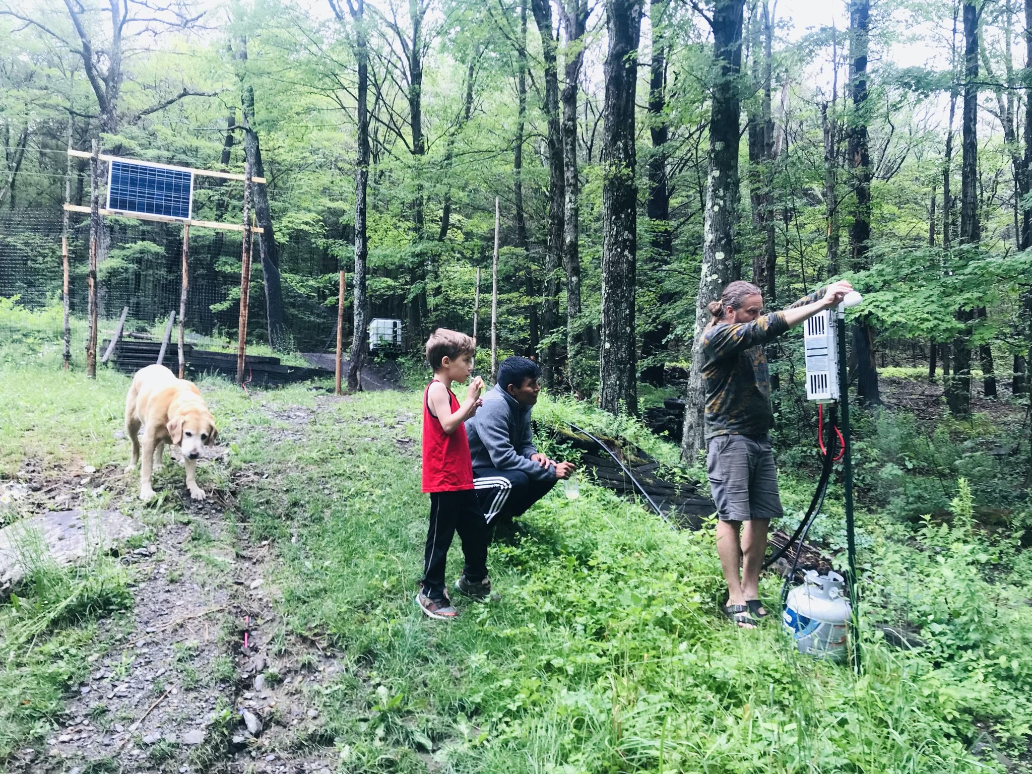 Micahel, Norberto, and Marek building the gravity fed water system