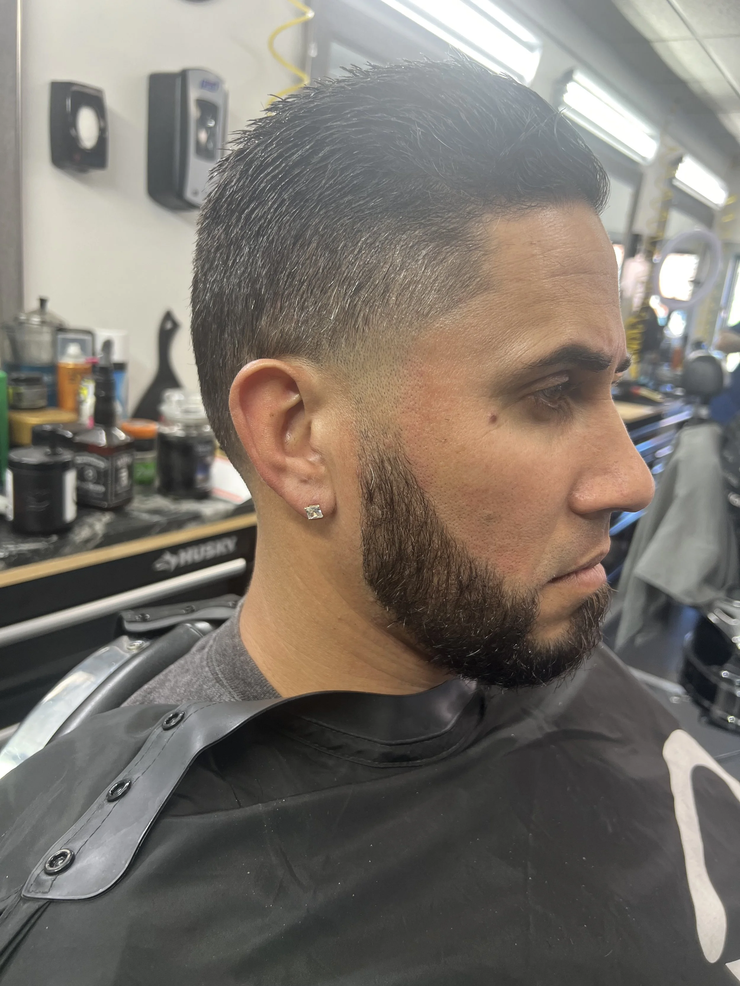 Man with a fresh haircut and beard trim in a barbershop.