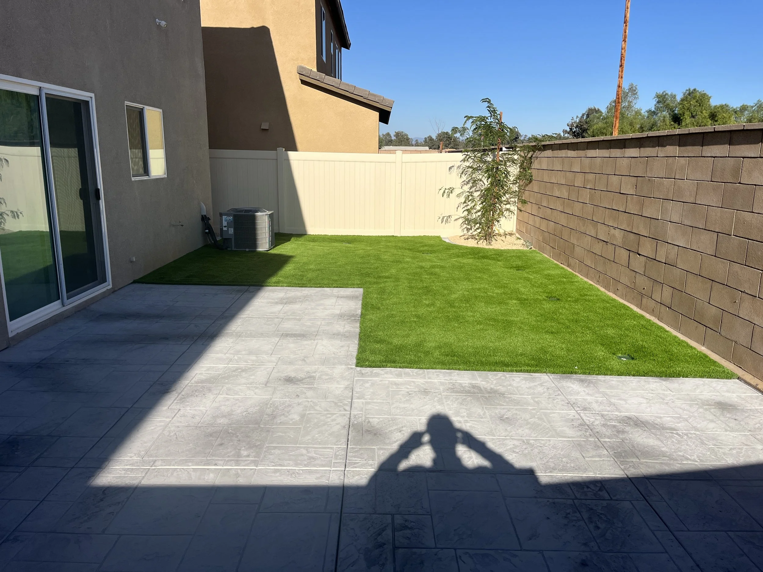 Backyard remodel in Menifee featuring stamped concrete patio and turf
