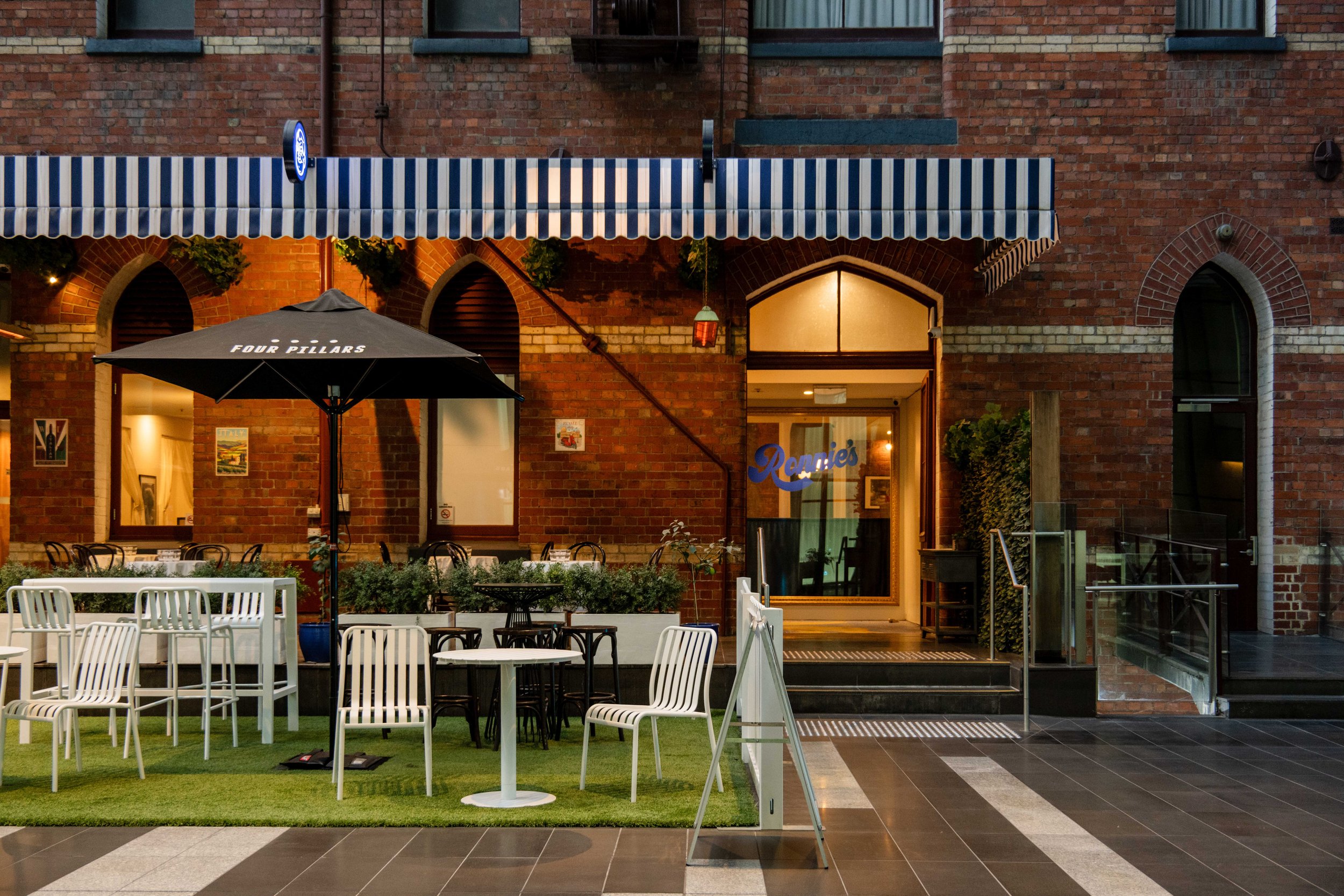 The Terrace at Ronnie’s on the Rialto Piazza at dusk, under the striped awning