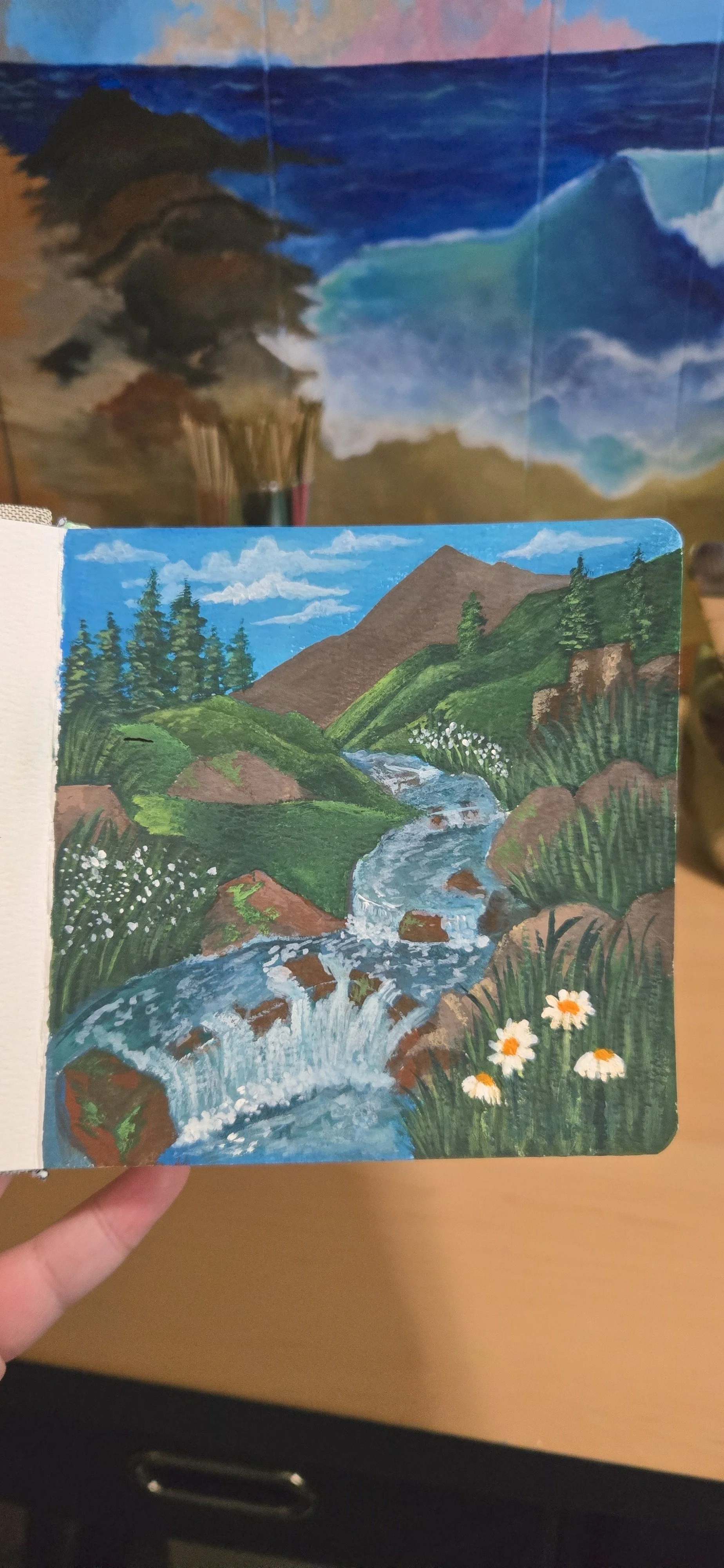 A hand-painted landscape of a mountain stream flowing through green hills with trees, flowers, and rocks under a blue sky.