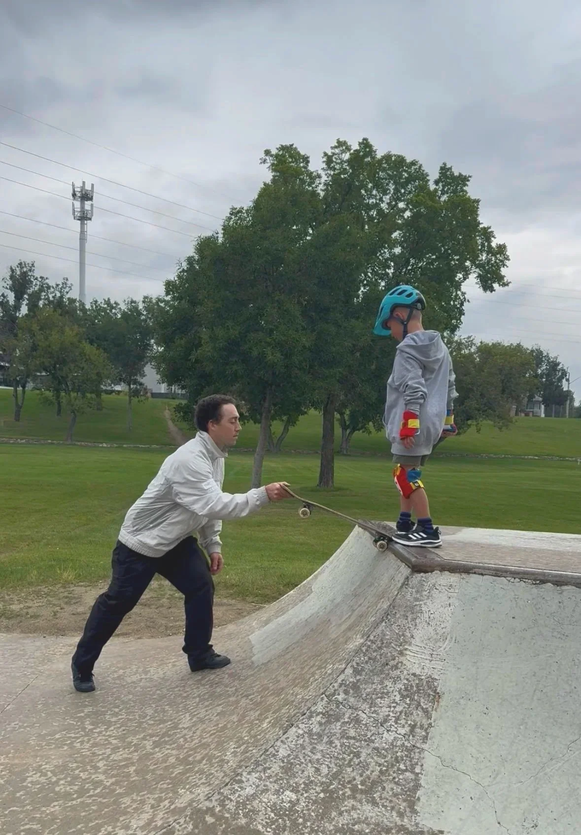 boy learns to drop in on a skateboard at lions skatepark in saskatoon with an instructor at skateboard lessons