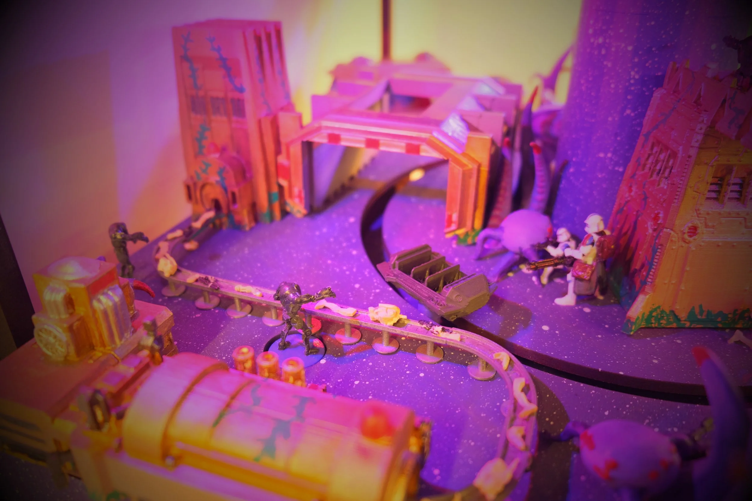 Colorful miniature castle and train set with figurines in vibrant lighting.