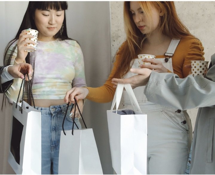 Two teen girls shopping, holding shopping bags.