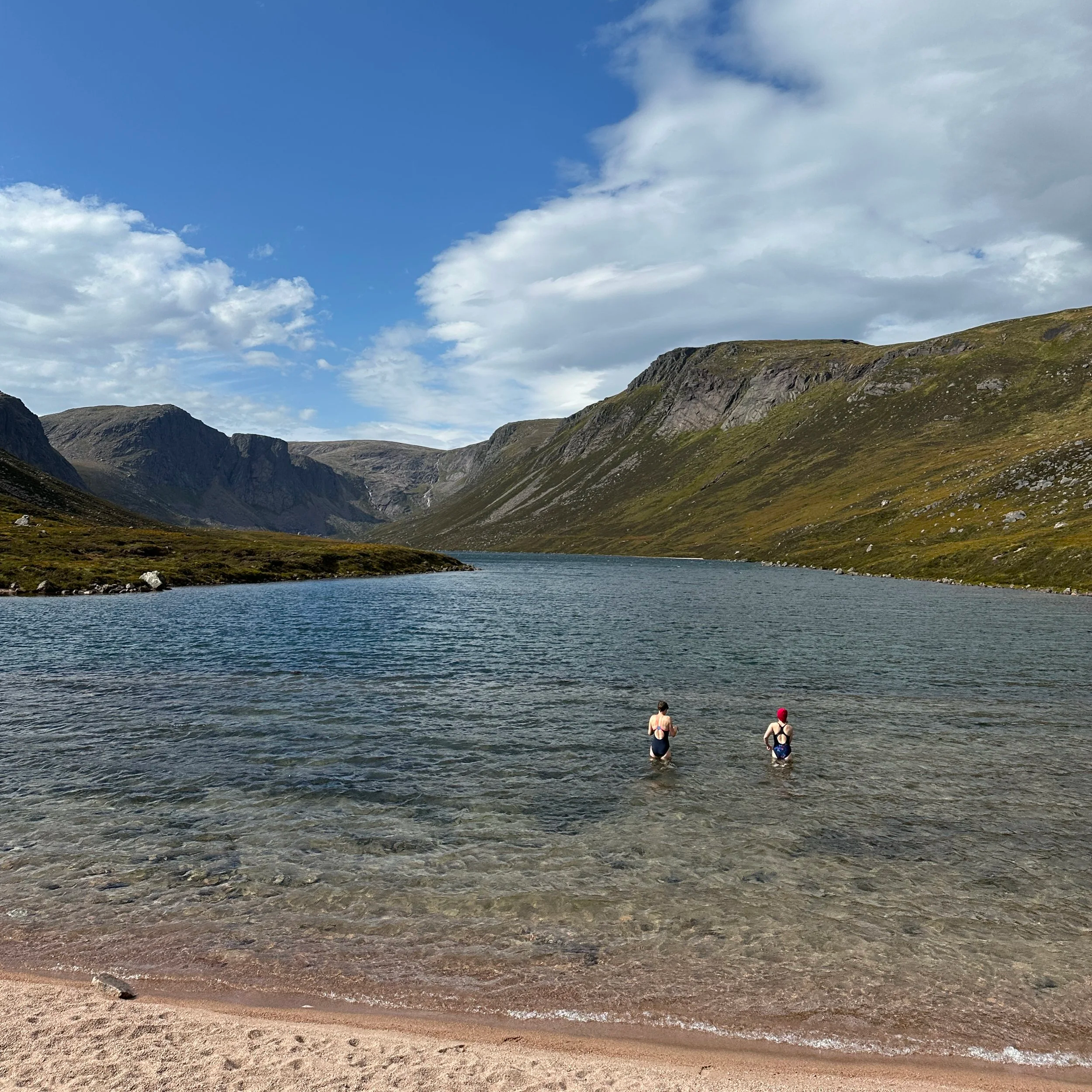 Two people going wild swimming in Loch Avon in the Cairngorms National Park