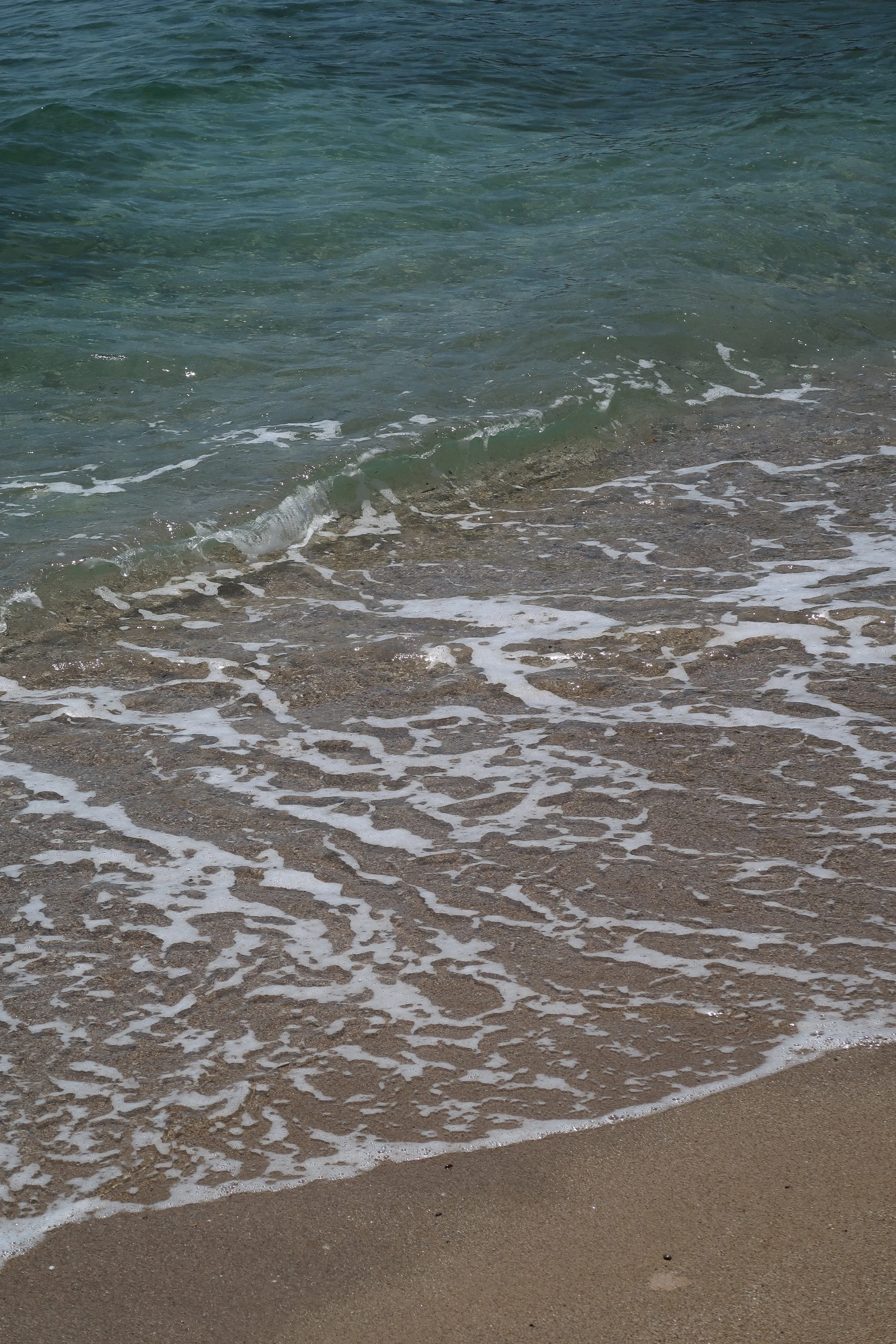 Ocean waves gently washing onto a sandy beach.
