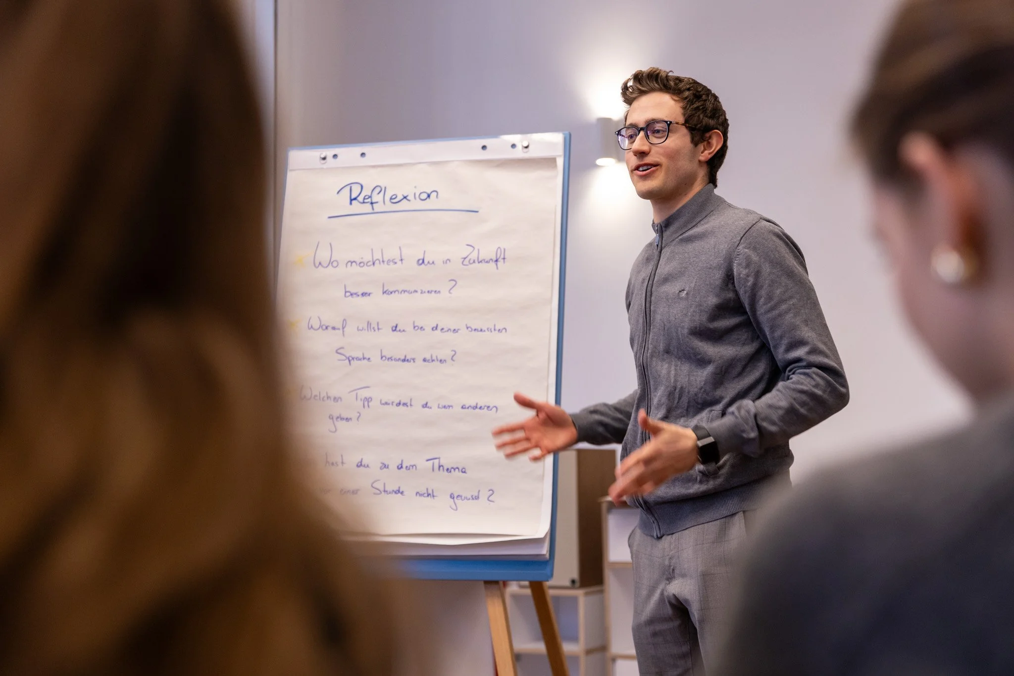 Mann mit Brille und blauem Shirt, wirkt selbstbewusst und ruhig
