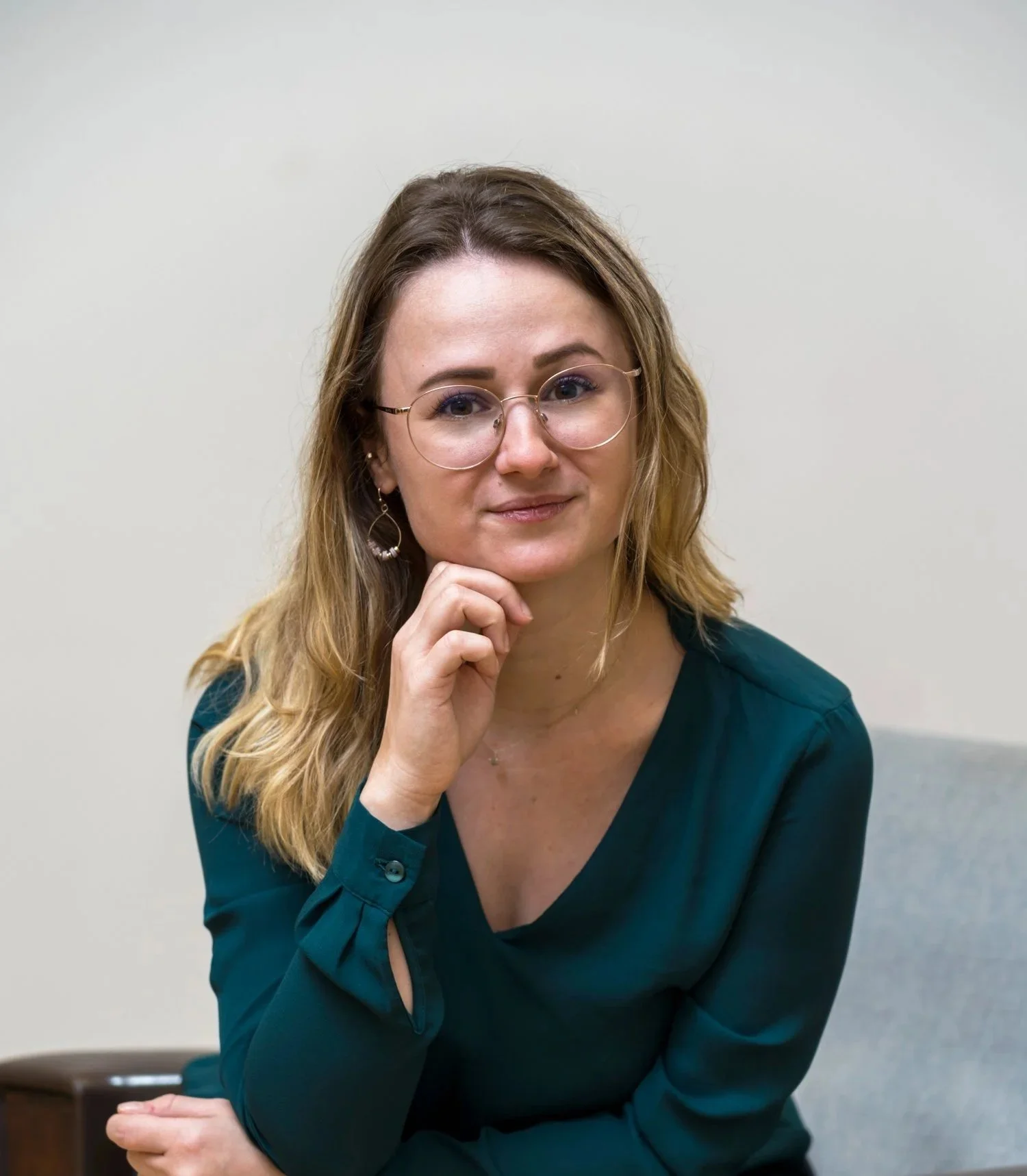 Junge, lächelnde blonde Frau mit hellblauer Bluse.