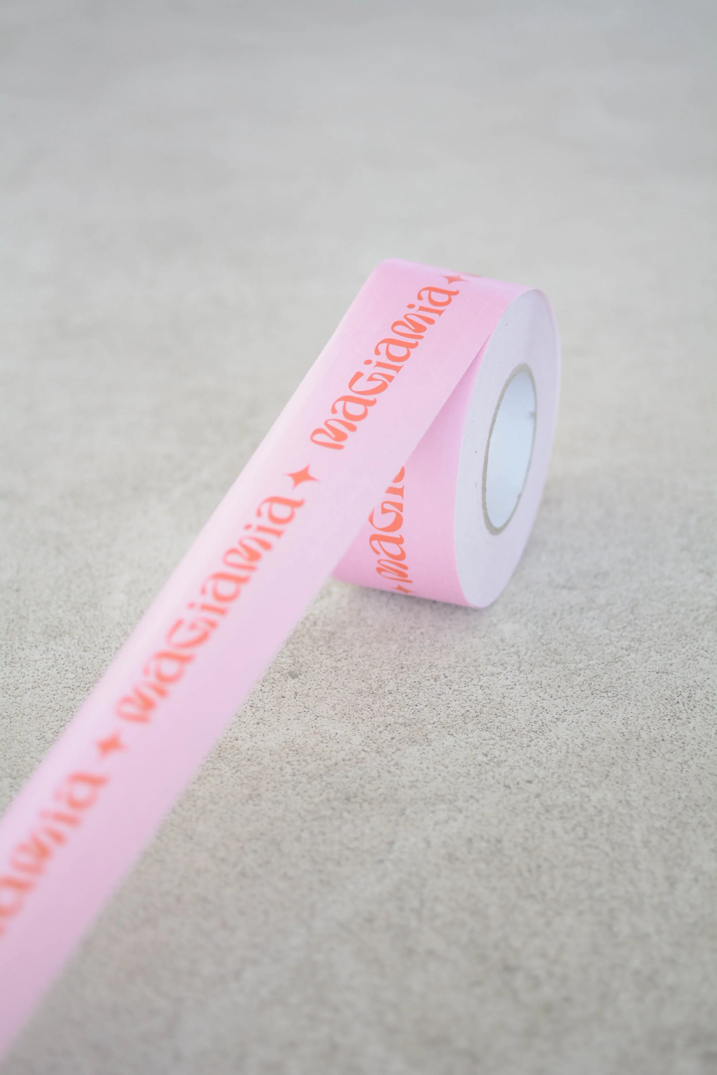 Cinta adhesiva rosada con la palabra 'Gracias' en letras naranjas y un símbolo de estrella pequeña. Diseño de logotipo para una marca de arneses de perro por GustoStudio en Asturias