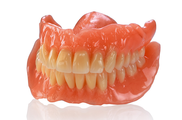 Gummi-Zahnersatz oder Prothese mit Ober- und Unterkiefer, aus Kunststoff, auf weißem Hintergrund.