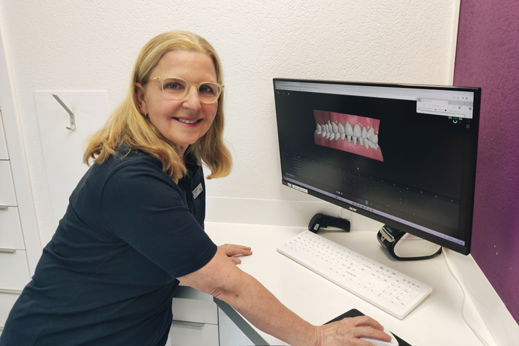 Zahnärztin zeigt 3D-Dentalmodell am Computerbildschirm.