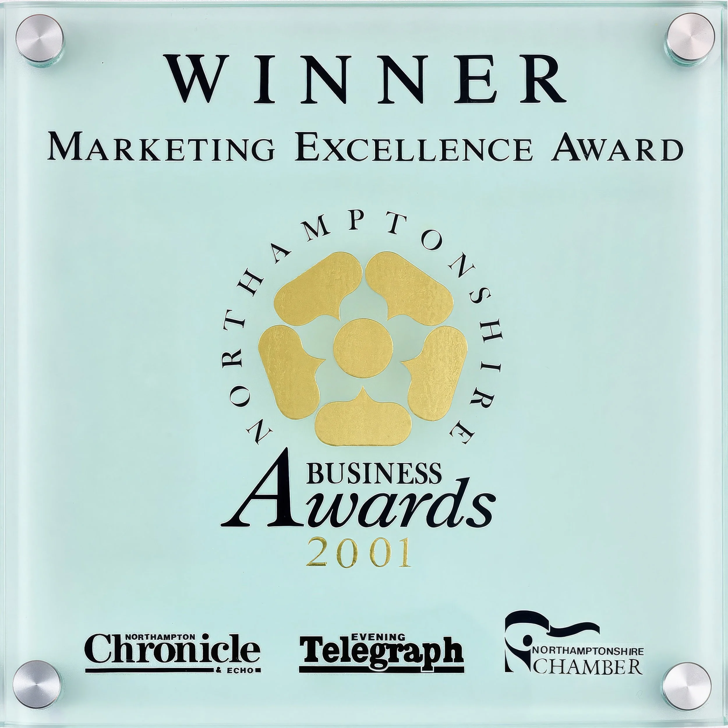 Our award for Imageview A glass award plaque with a gold flower design in the center, engraved with "Winner Marketing Excellence Award 2001" and logos of Northampton Chronicle, Evening Telegraph, and Northamptonshire Chamber.