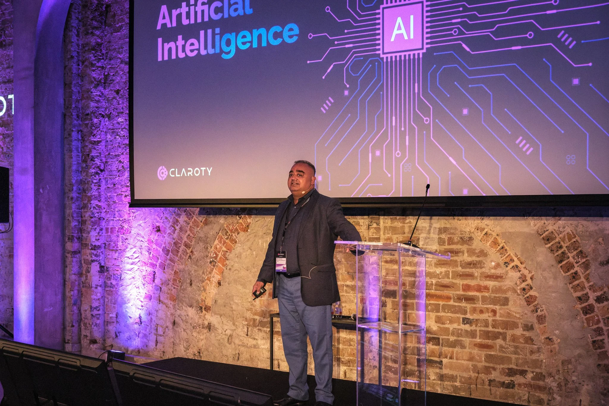 Corporate event photographer Sydney — speaker presenting at conference with brand screen