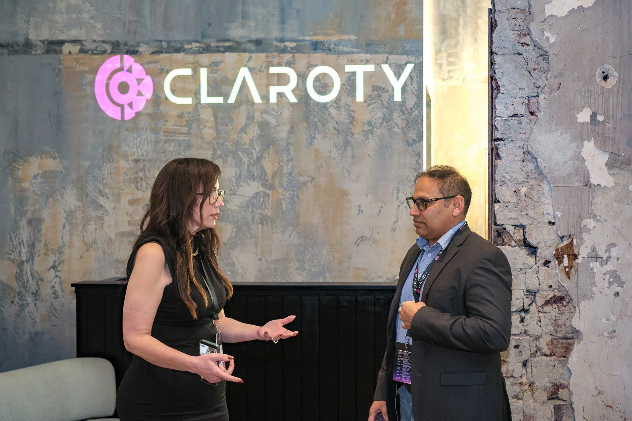 Corporate event photographer Sydney — candid conversation at corporate event with brand signage
