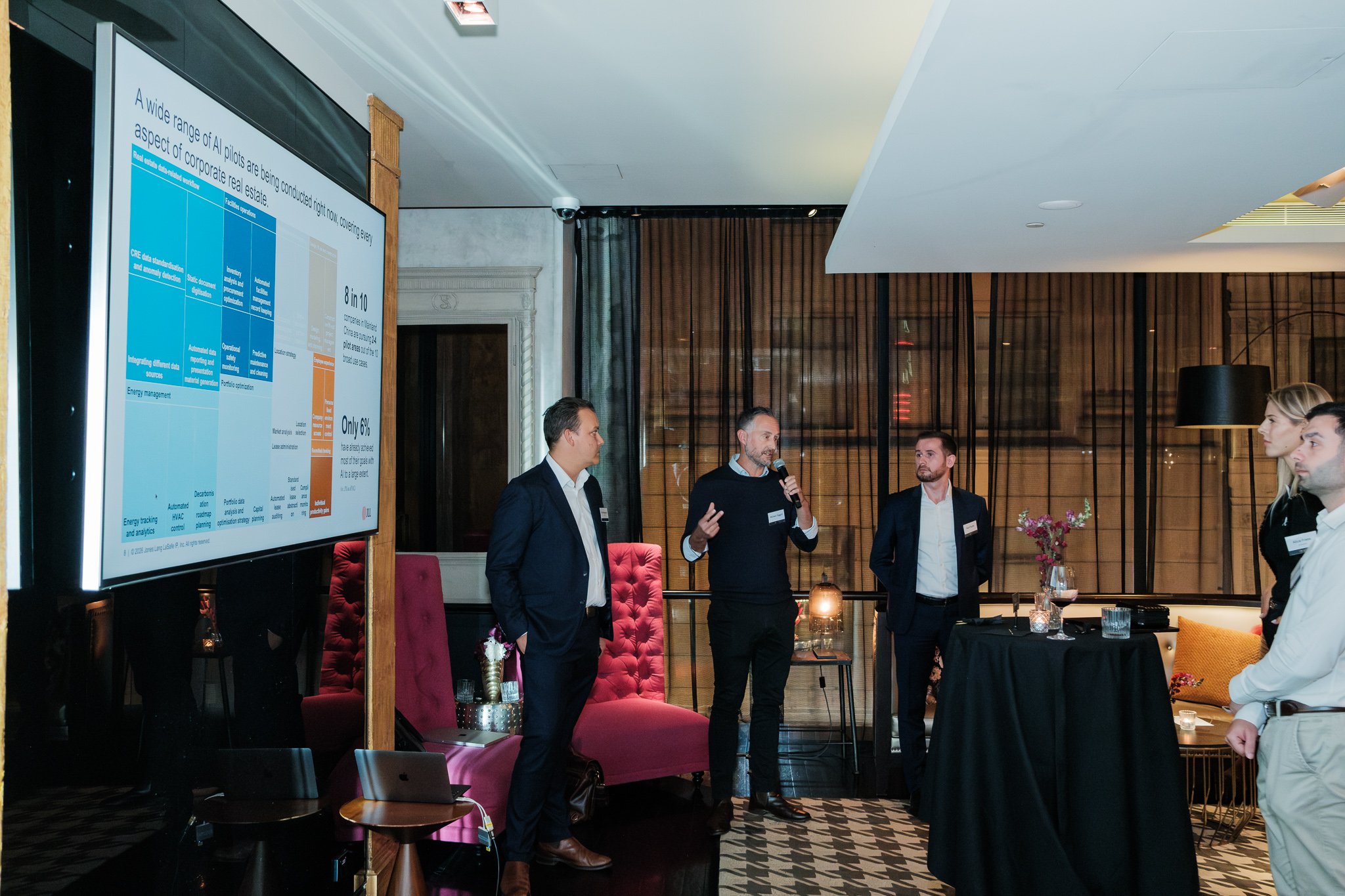 The event program on screen alongside the hosts — a structured, brand-rich image that works equally well for internal comms and post-event recaps