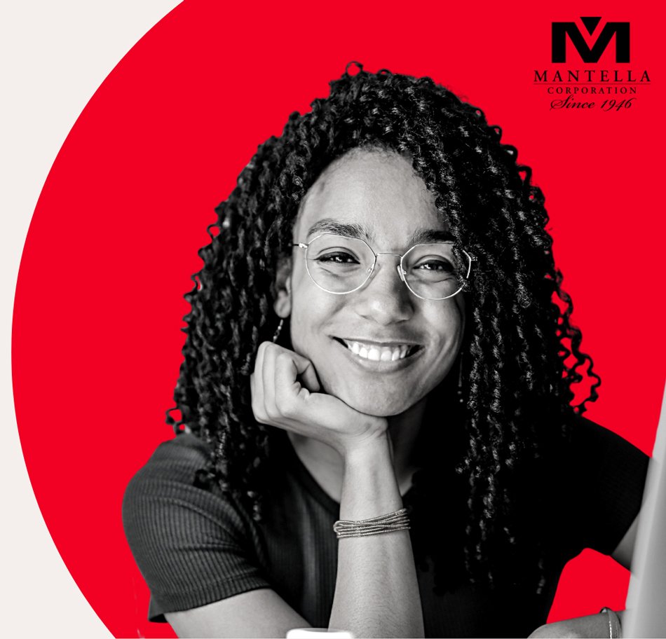Smiling woman with curly hair and glasses, resting her chin on her hand, against a red and gray background with the Mantella Corporation logo in the top right corner.