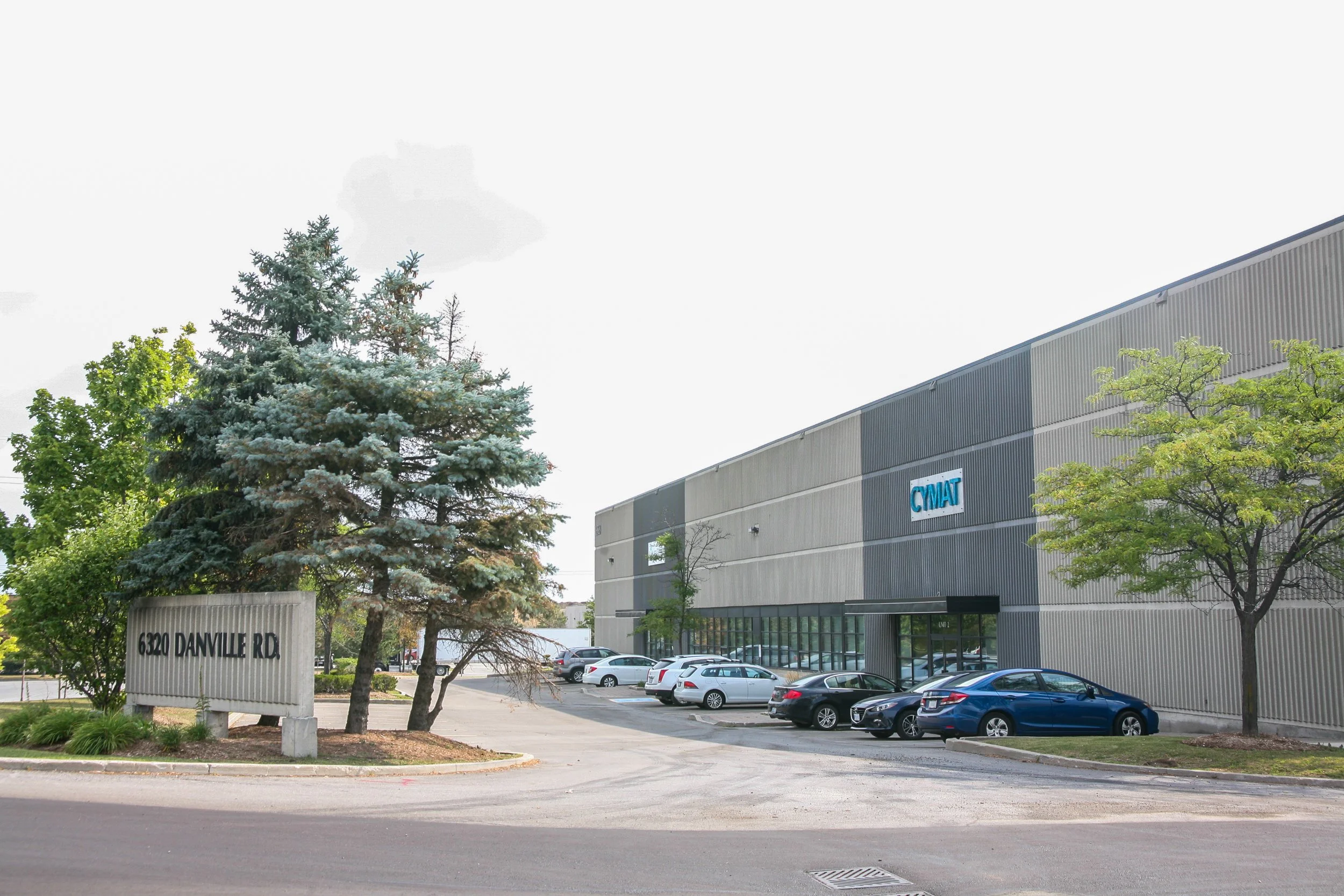 Commercial building with parking lot and trees in front, street sign reading 6320 Danville Rd.