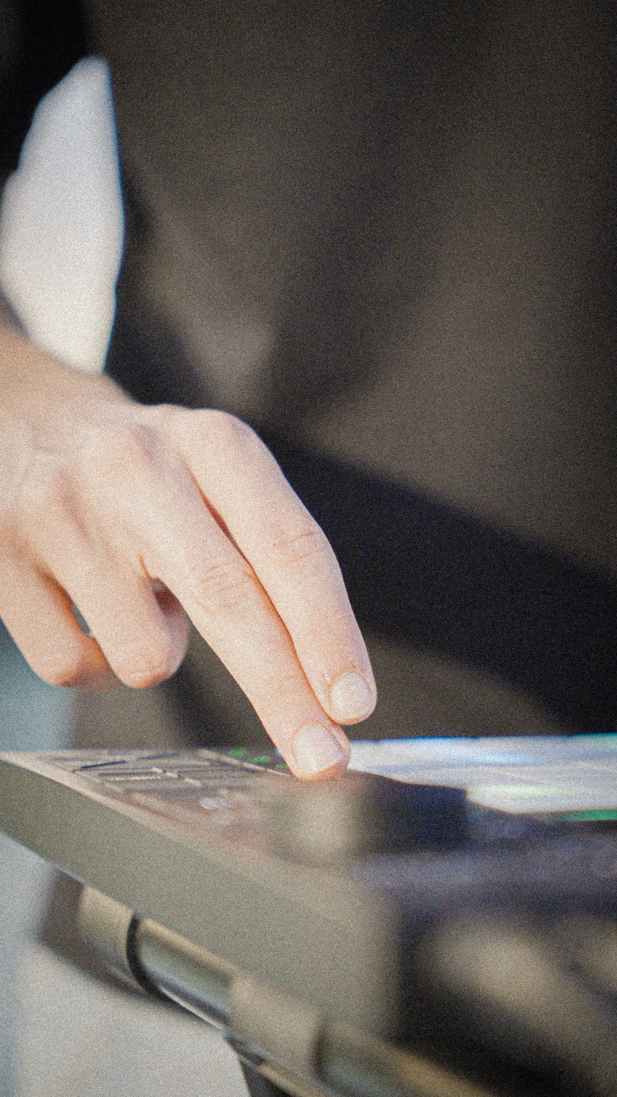 Close-up of a person's hand touching a touchscreen device.