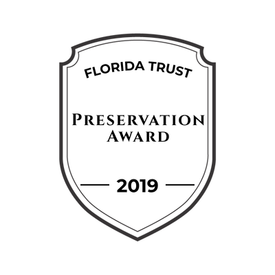 A black shield outline with a small crown at the top center.