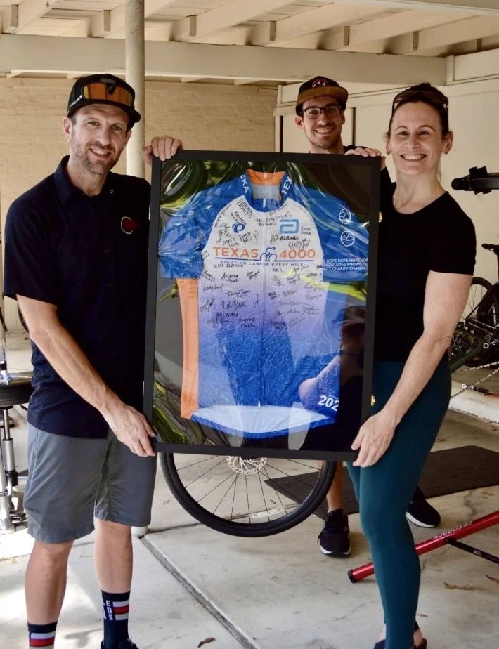 Bev holding a framed jersey, presenting to supporters