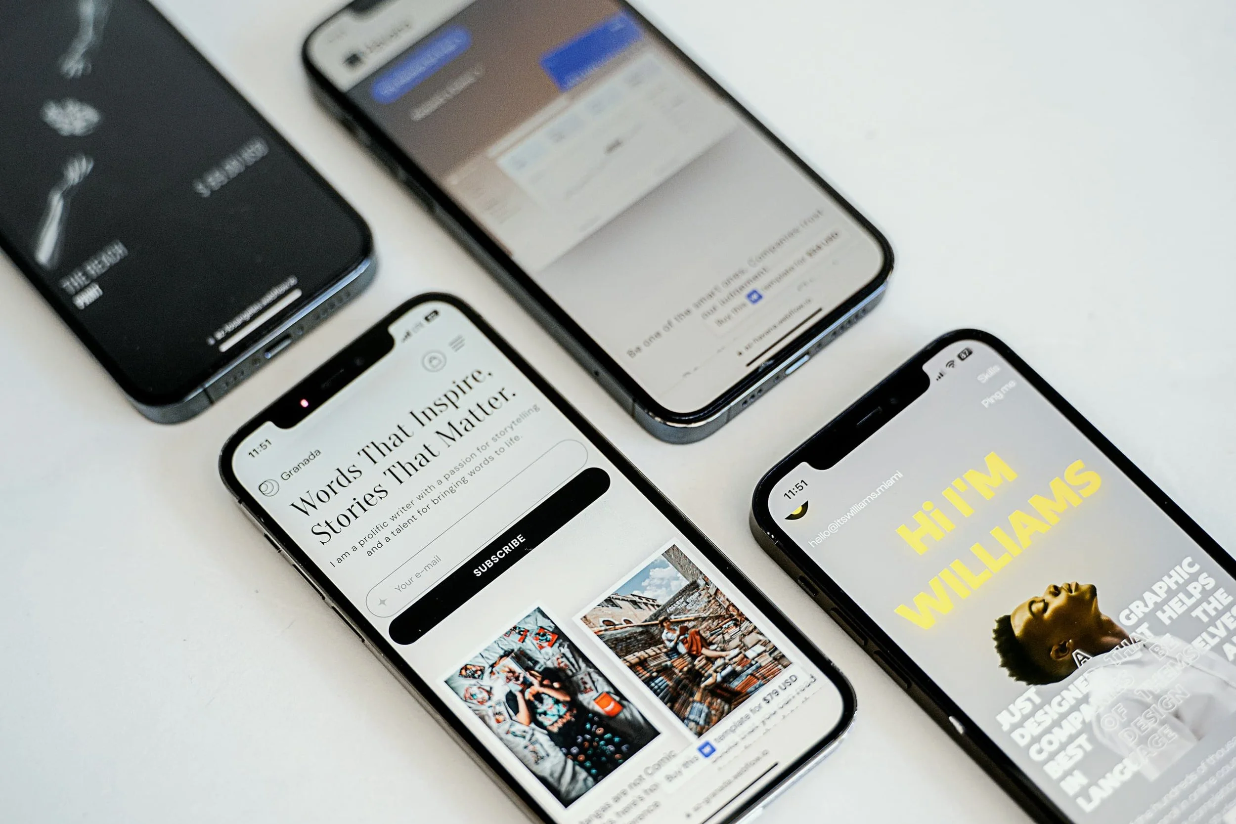 Multiple smartphones displaying different screens, including a newsletter subscription page, a news article, and a graphic design webpage, placed on a white surface.
