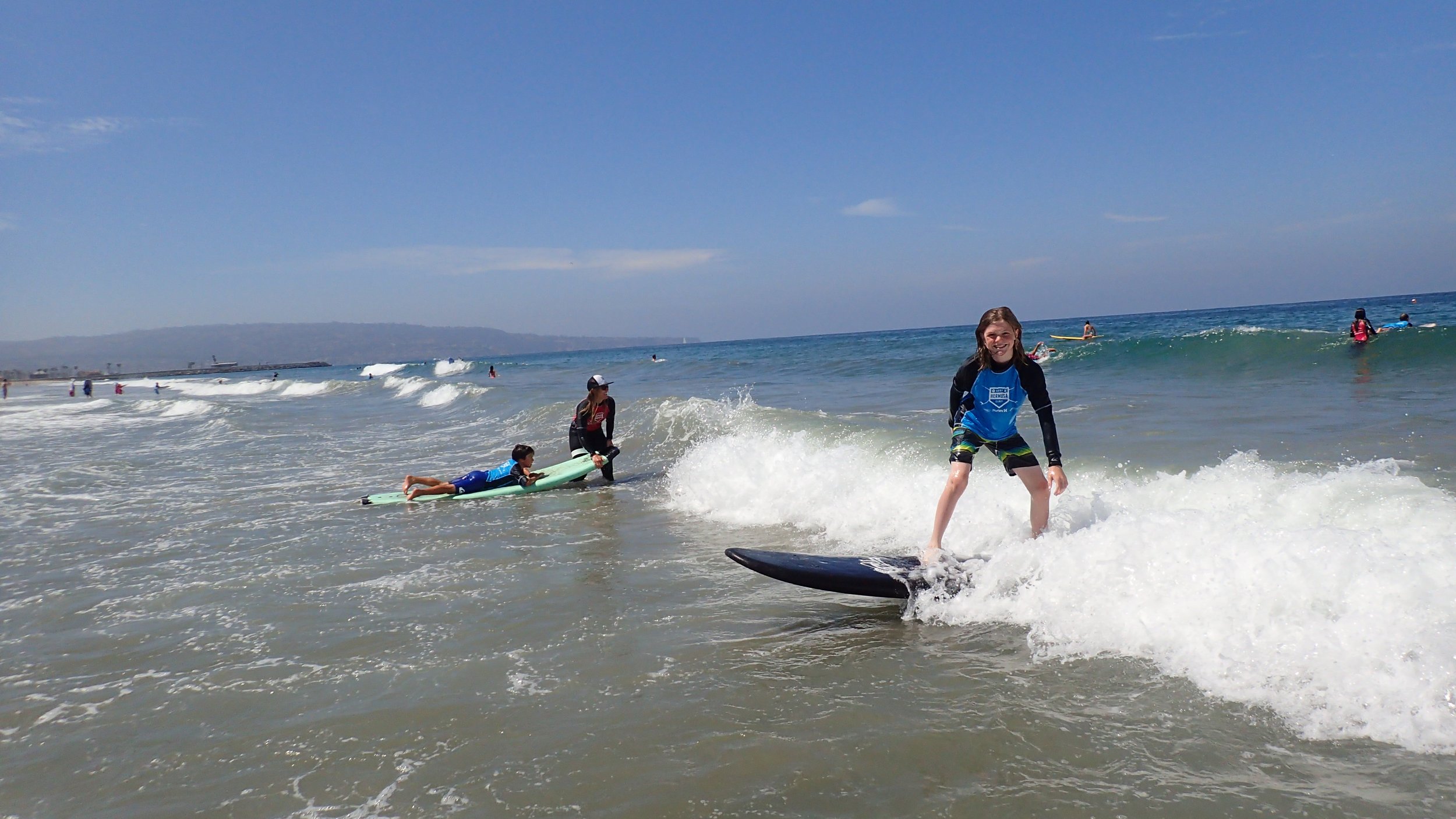 Children surfing and playing in the ocean on a sunny day
