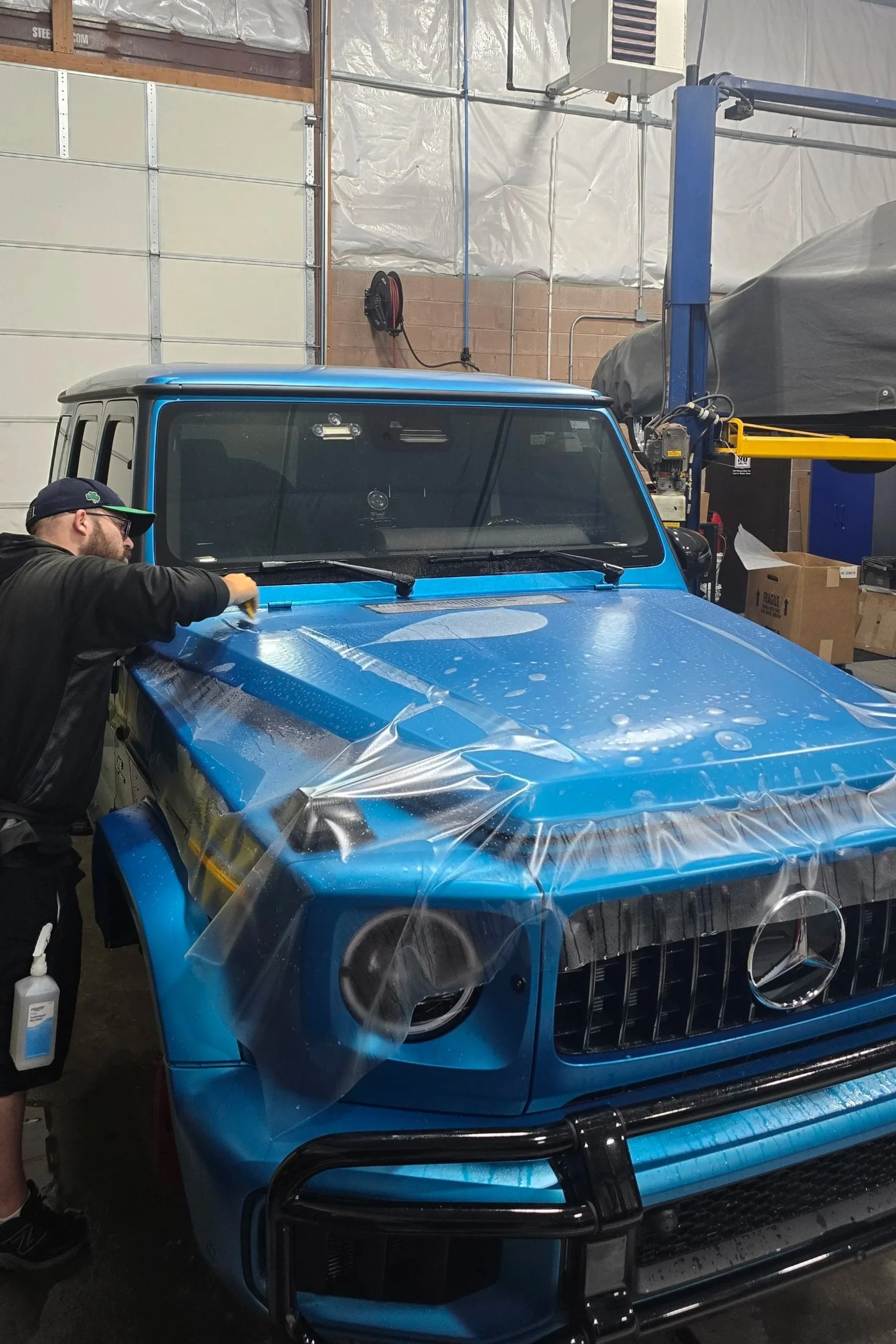 applying a protective vinyl wrap to a blue Mercedes-Benz G-Class SUV Xpel Ultimate Plus
