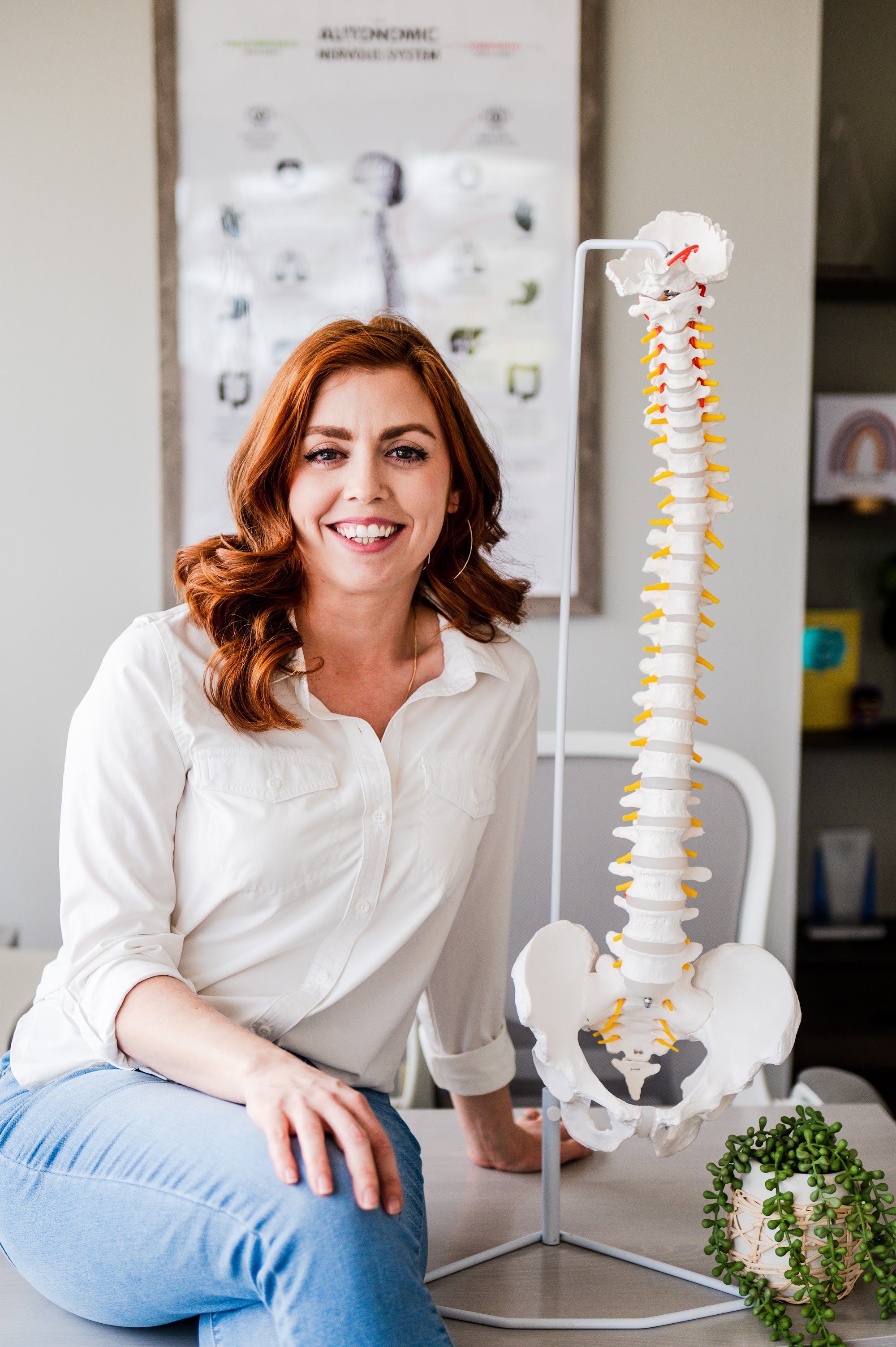Dr. Shannon Bundy with a spine model, chiropractic care at The Wellness Way Westminster