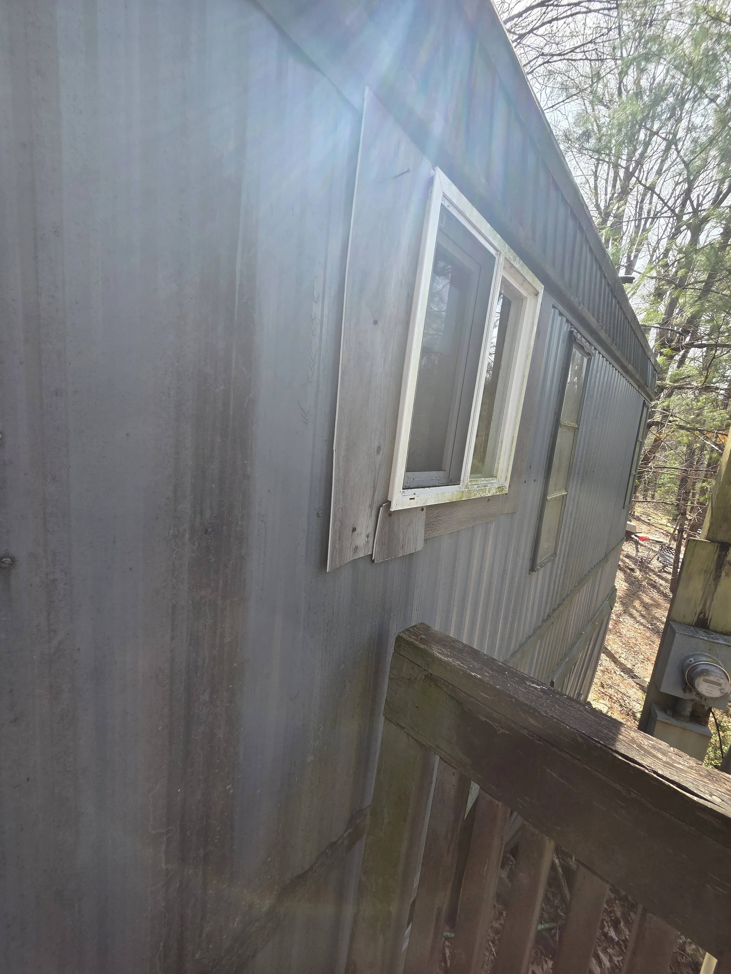 An exterior window being trimmed improperly using LVP flooring on the exterior of the siding panels.