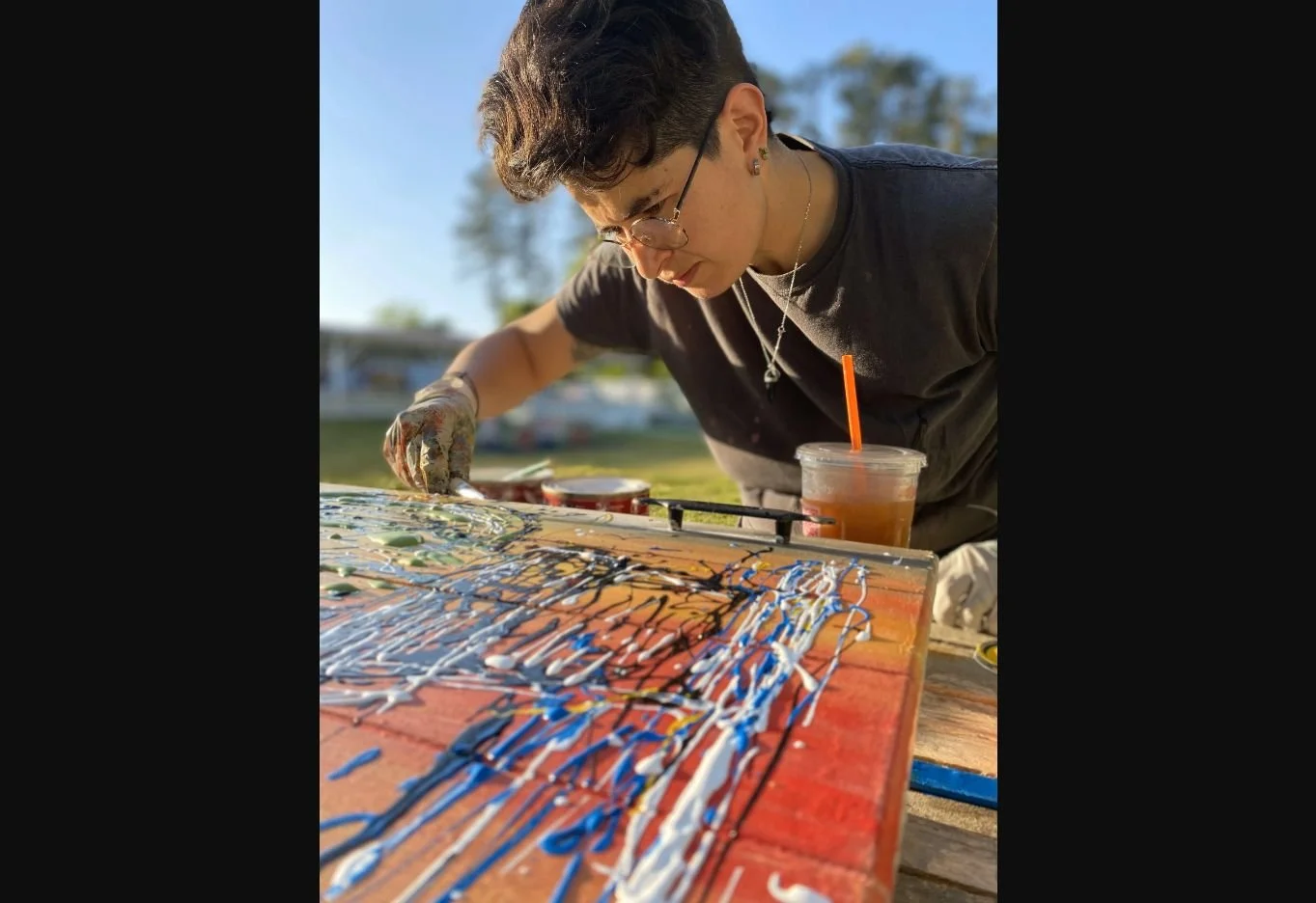 Laura painting a colorful OpenDoors artwork outdoors