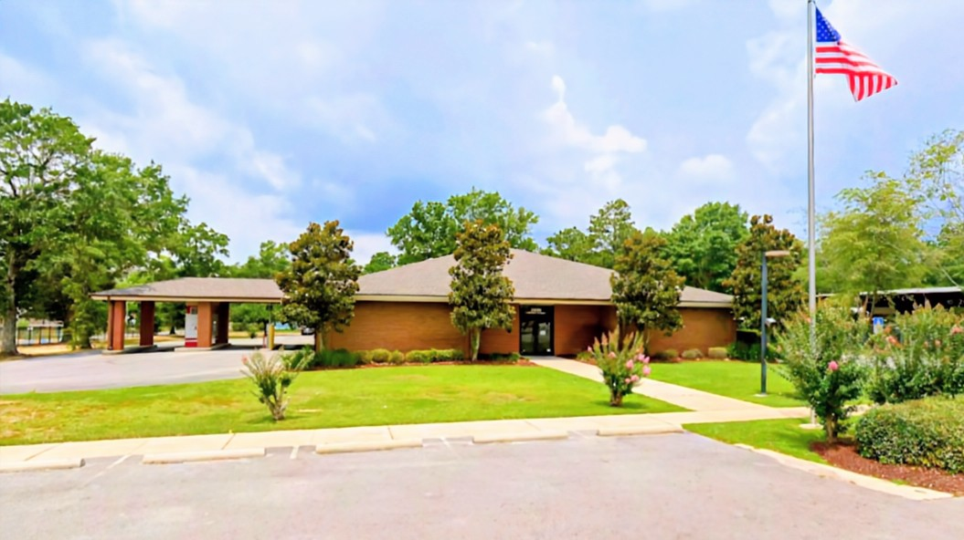 Exterior of Santa Rosa County Federal Credit Union Main Branch on North Stewart Street in Milton, FL, a brick building with landscaped lawn and American flag.