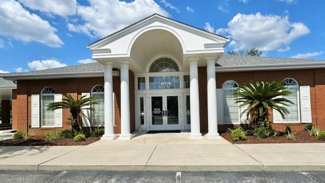Exterior of Santa Rosa County Federal Credit Union Pace Branch on Highway 90 in Pace, FL, a brick building with white columns and arched entryway.