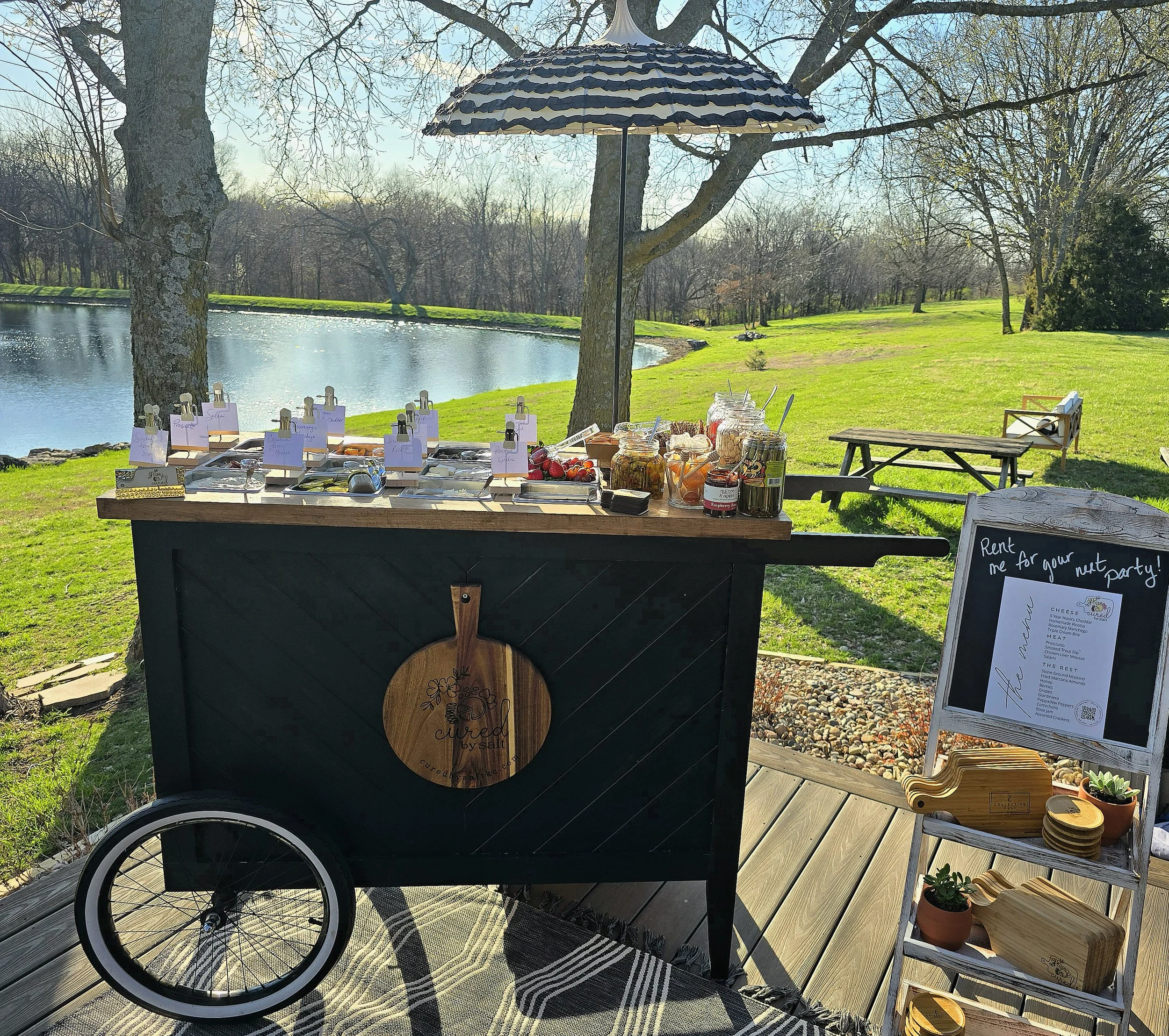 Cured by Salt charcuterie cart set up beside a pond for a private event in the Kansas City area