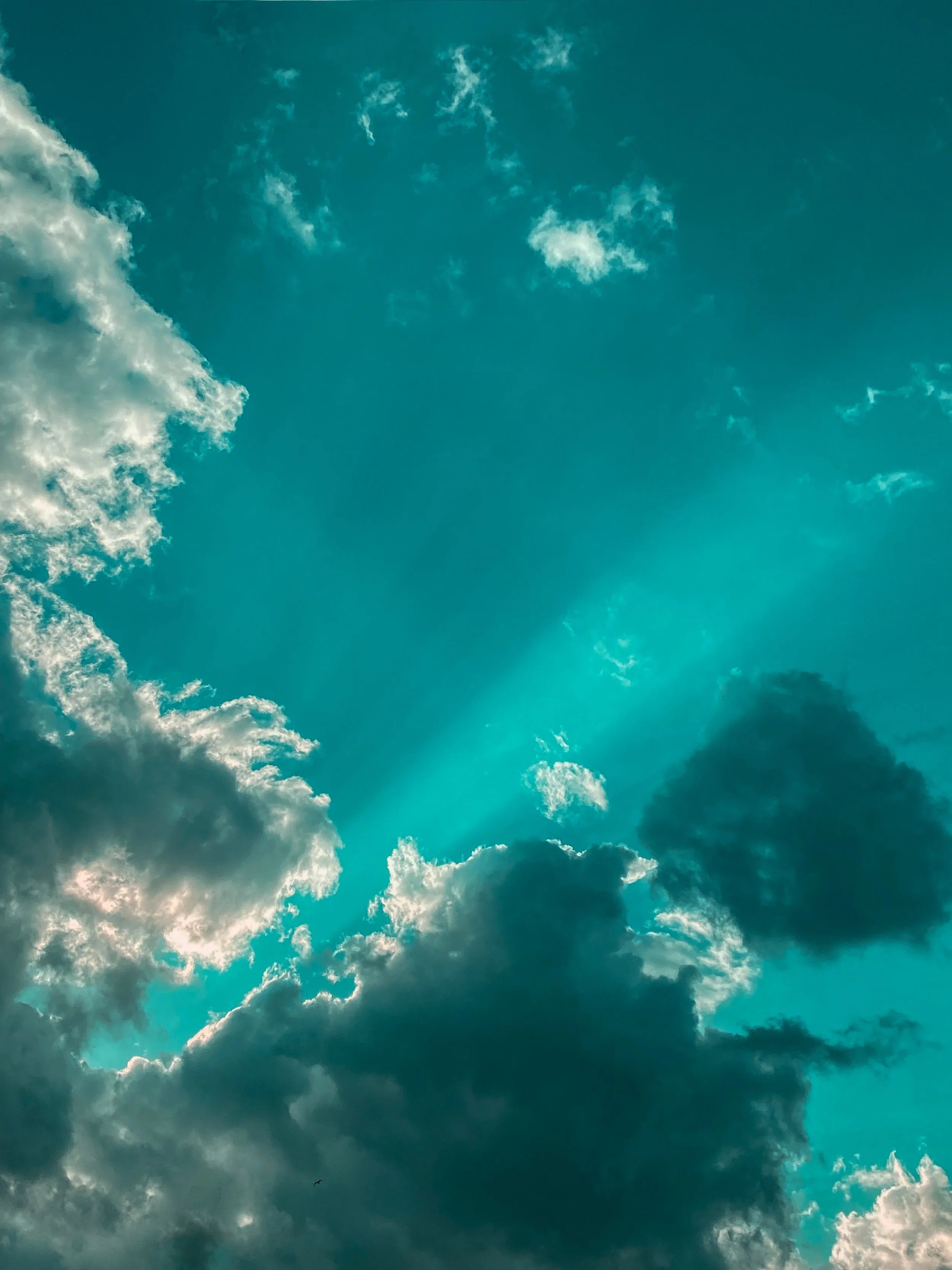Clouds with turquoise sky and sun rays