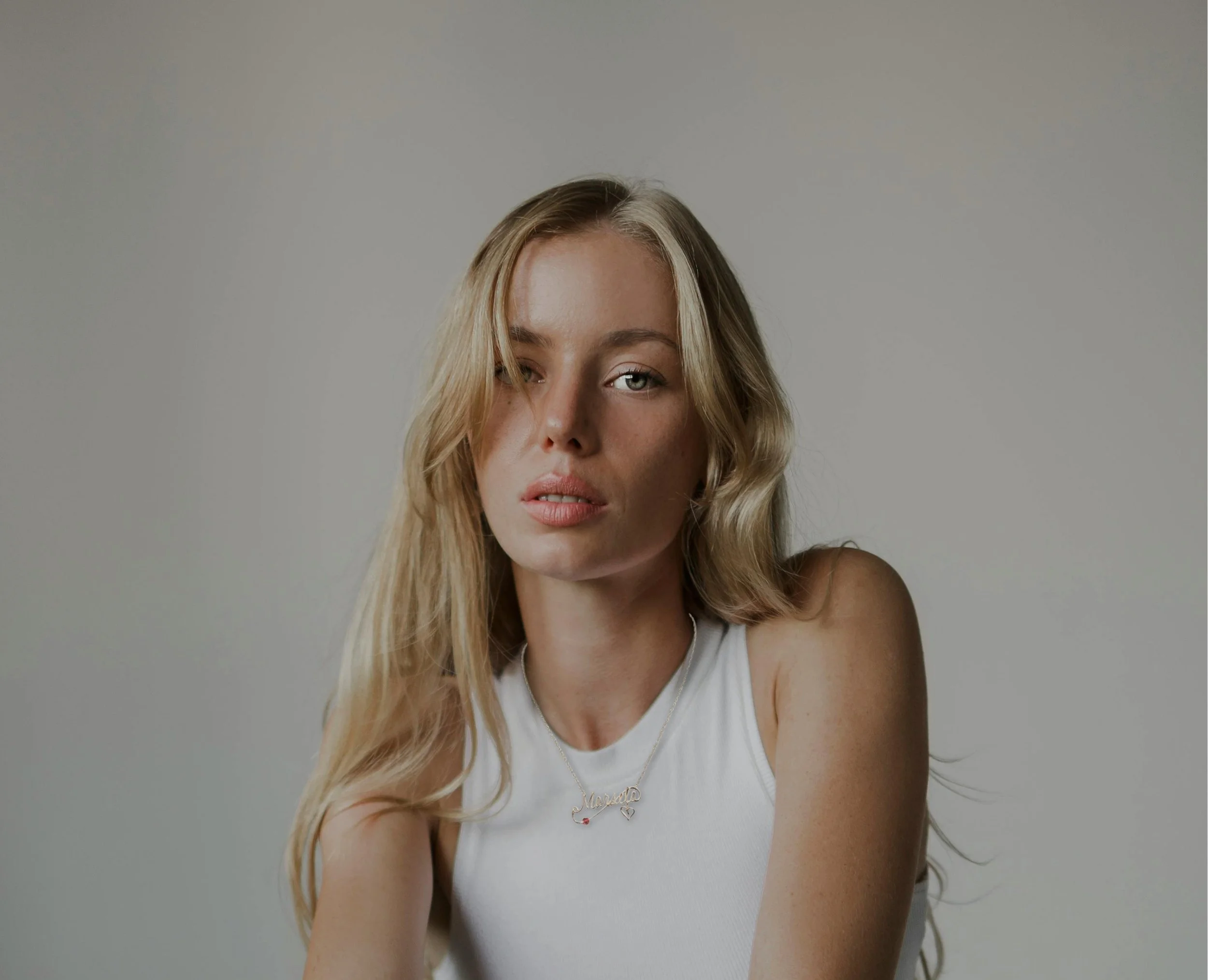 Necklace display featuring handcrafted wire jewelry with customizable name charms.