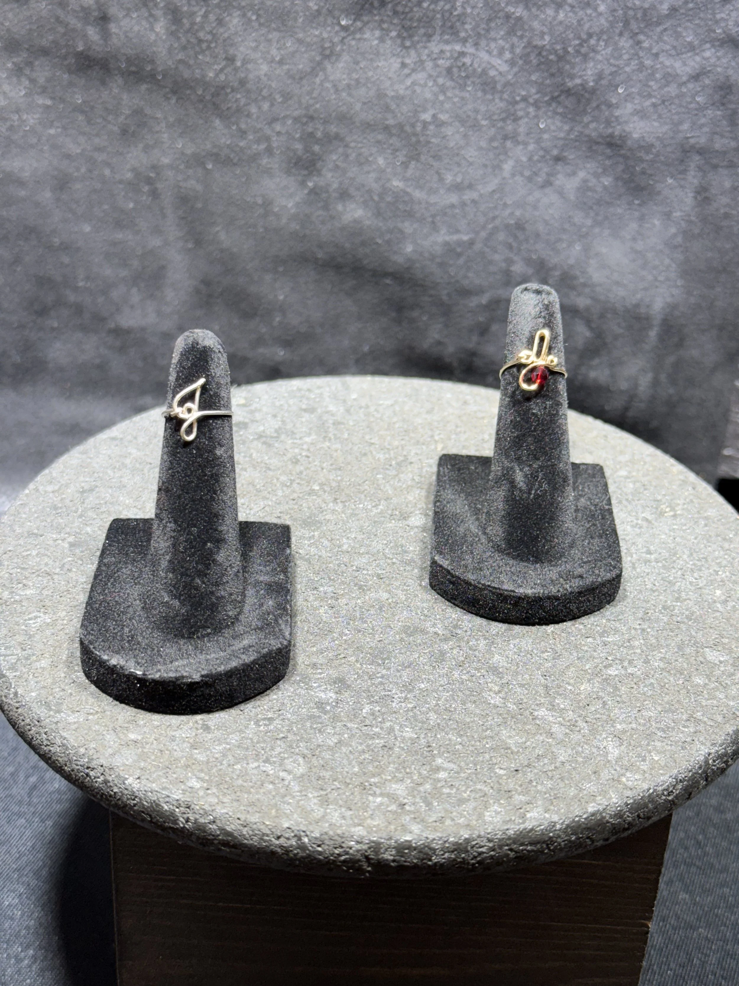 Personalized wire ring with a minimalist initial detail.