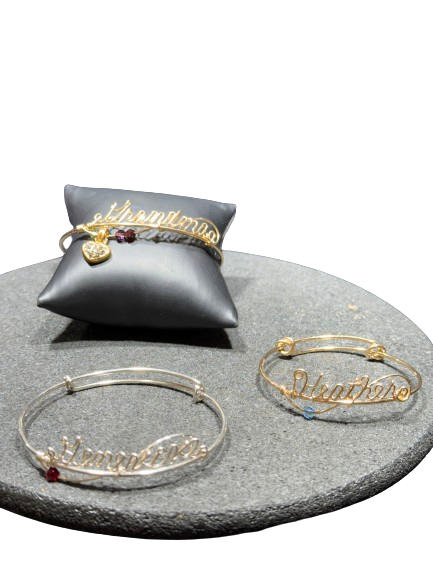 Handcrafted wire bracelet with personalized name and custom charm options.